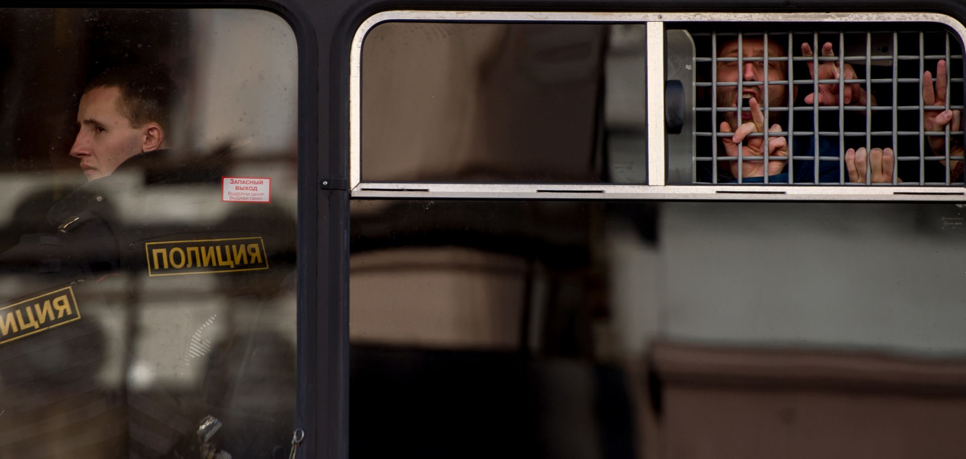 Protesters gesture from a police bus after being detained during an unauthorized anti-corruption rally in central Moscow on March 26. 