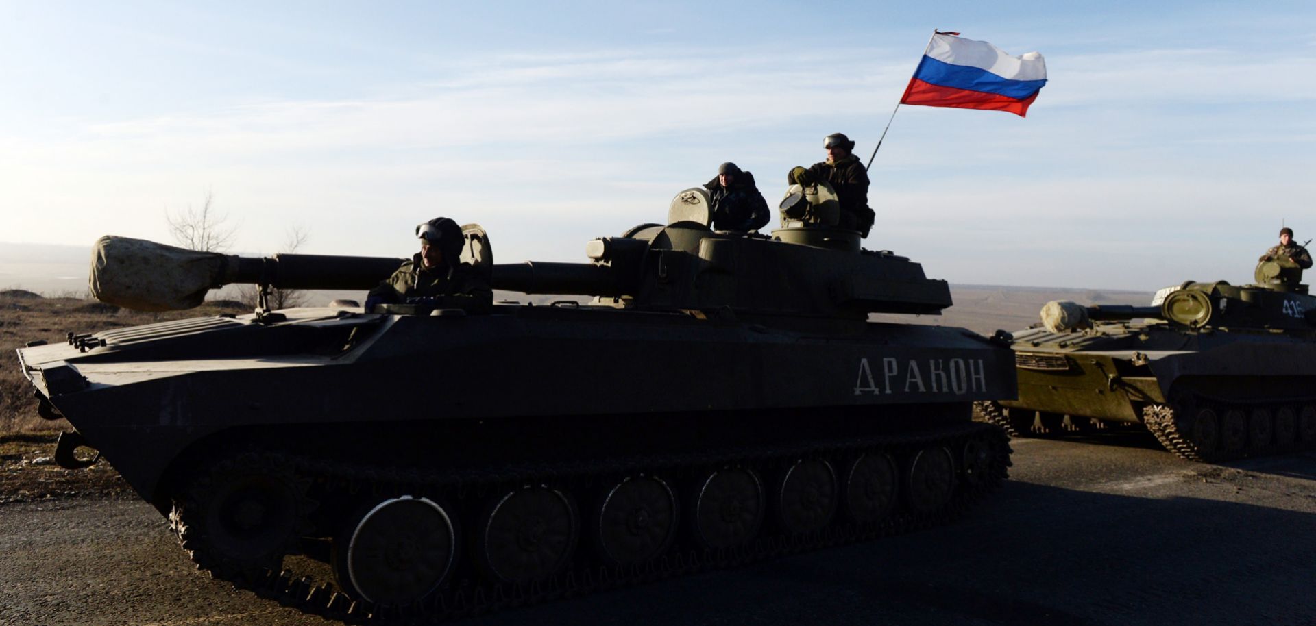 A Russian flag flies near pro-Russia militants sitting atop a 2S1 Gvozdika self-propelled howitzer as a convoy takes a break in the Donetsk region.