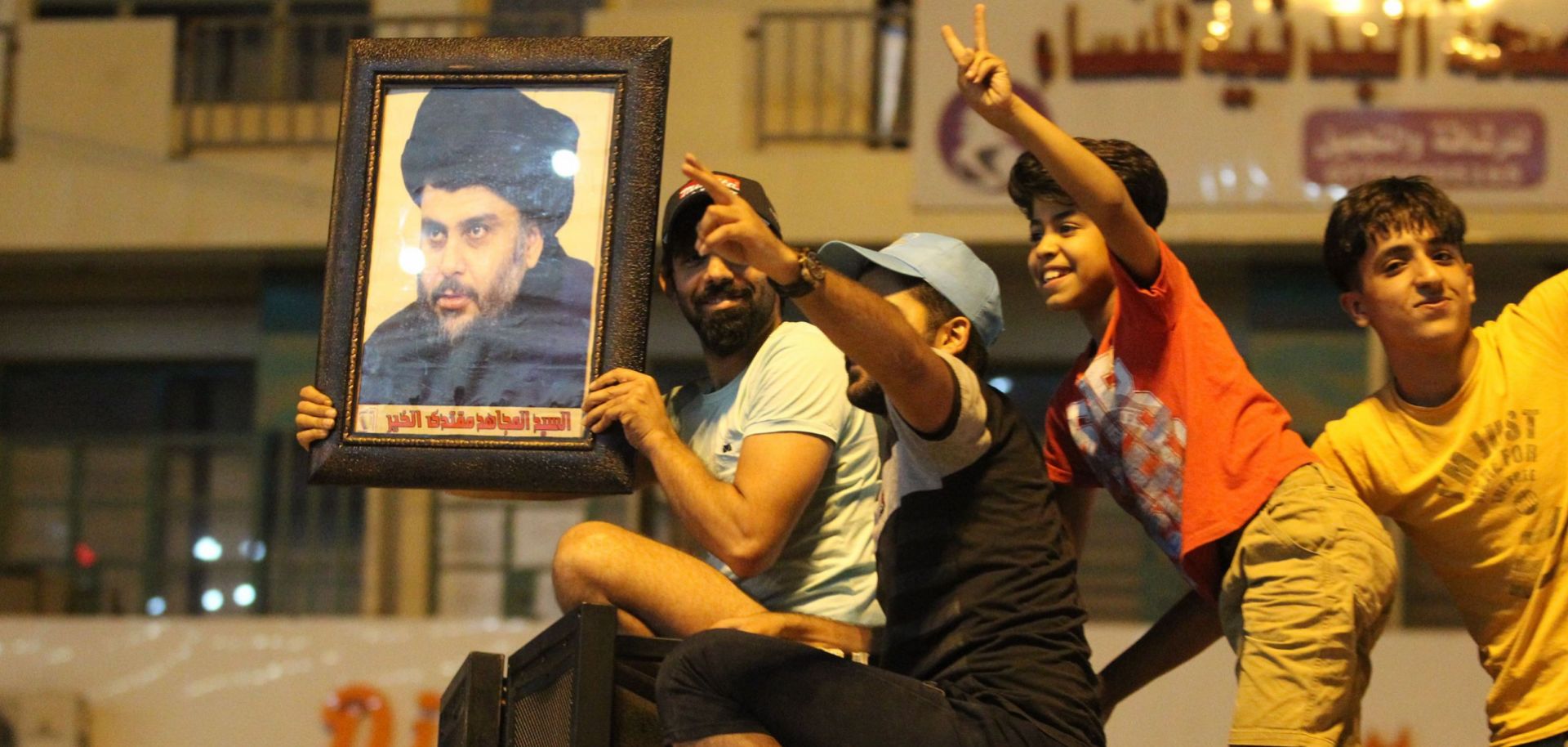 A supporter of Muqtada al-Sadr holds up a picture of the Shiite leader as Iraqis celebrate in Baghdad on May 14, 2018.