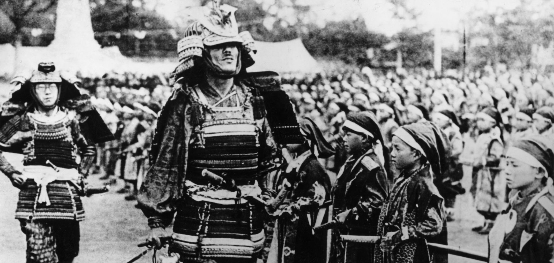 Different generations of samurai mingle at a pageant in Japan, circa 1930. 