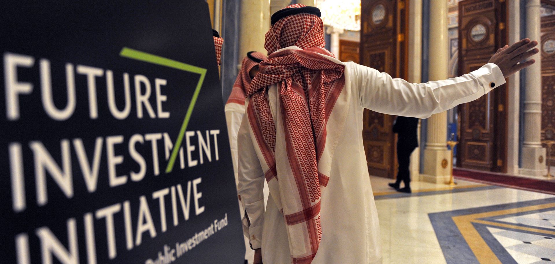 A Saudi man gestures near a sign at the start of the three-day Future Investment Initiative in Riyadh on Oct. 23, 2018.
