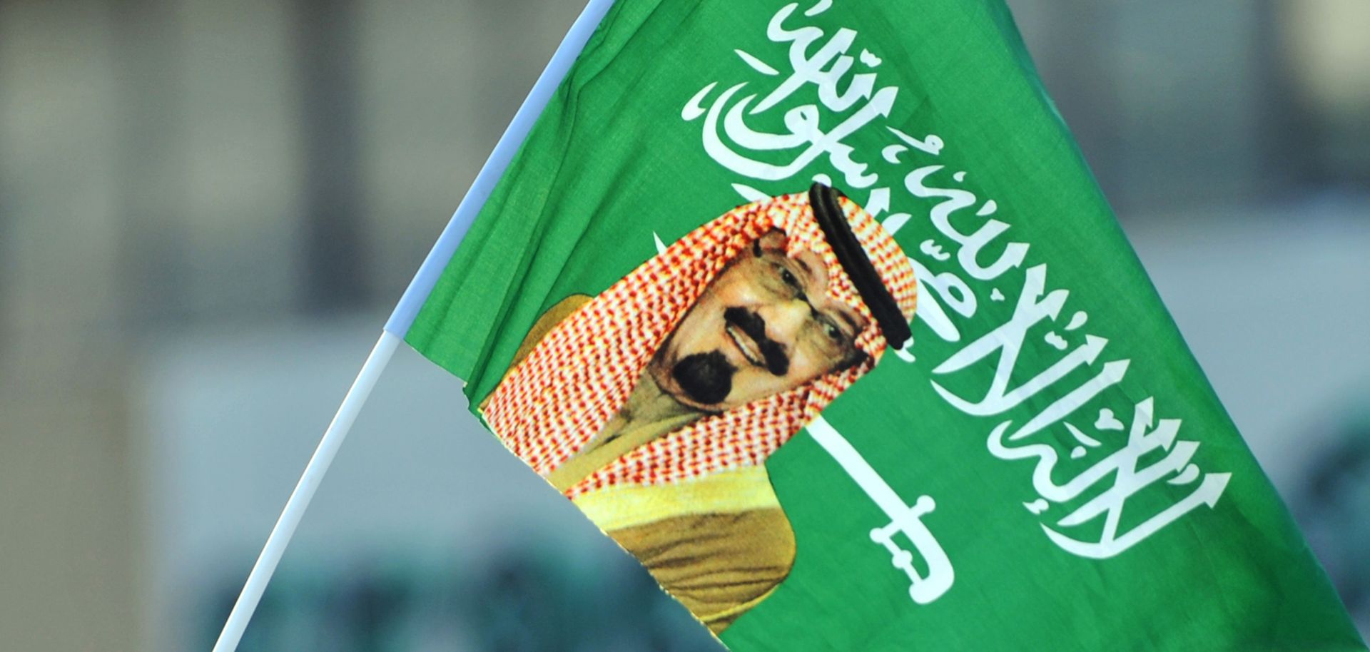 A child waves a flag with a picture of King Abdullah in September 2013.