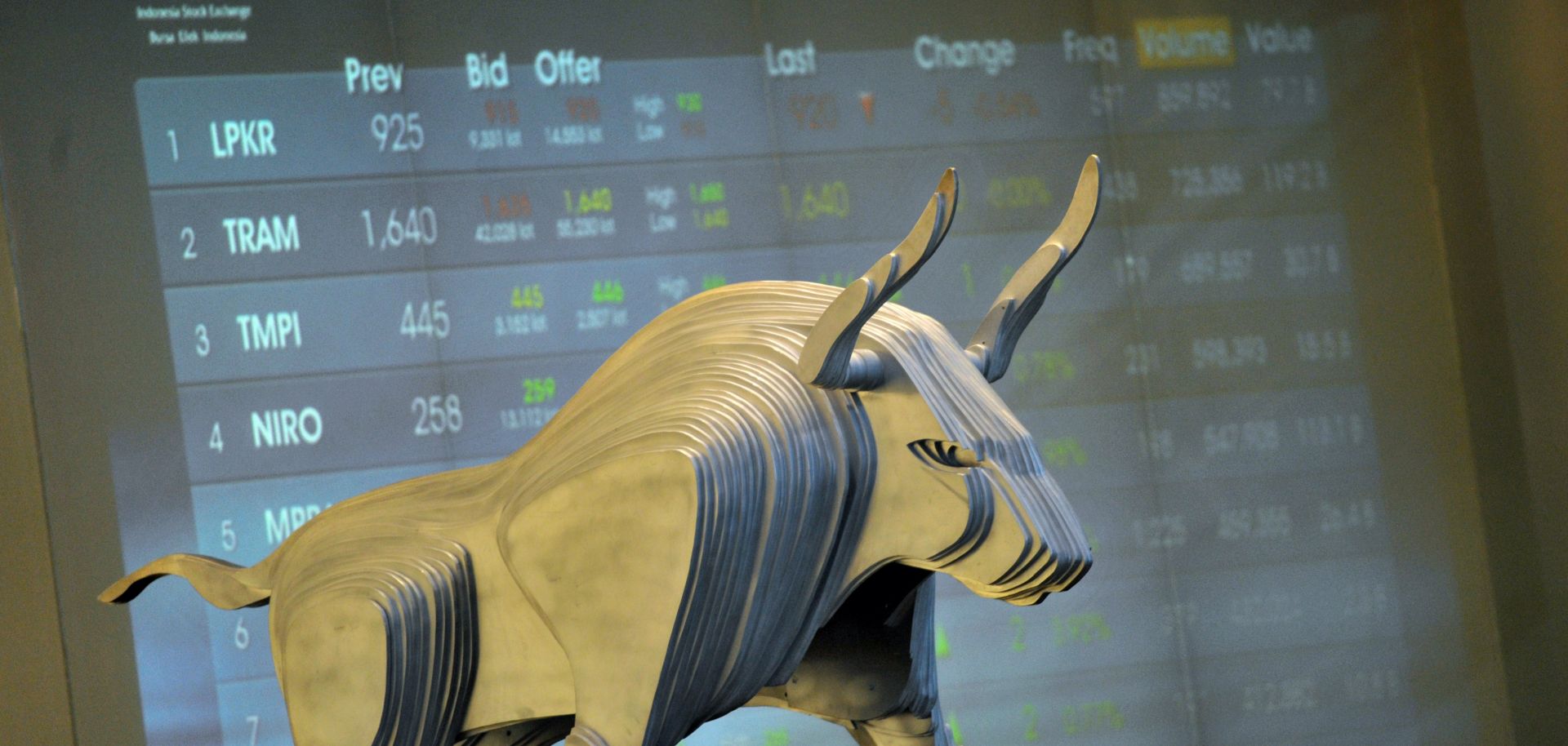A modern iron sculpture of a bull stands in front of the Indonesia Stock Exchange display in Jakarta.