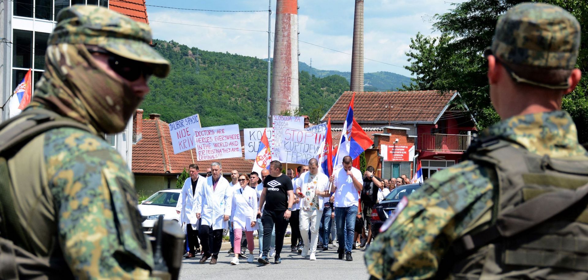 NATO peacekeepers stand guard as hospital employees lead a protest march of ethnic Serbs in northern Kosovo on June 19, 2023. 