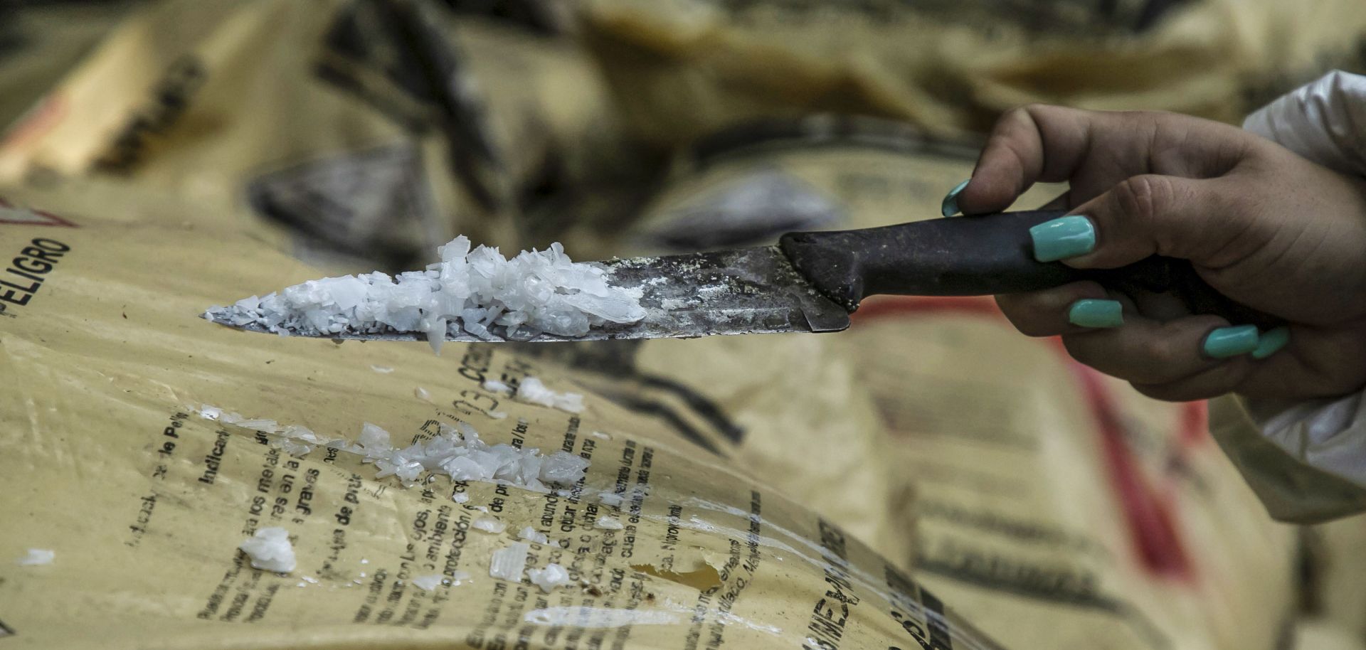 A police officer holds a spade covered in methamphetamine. 