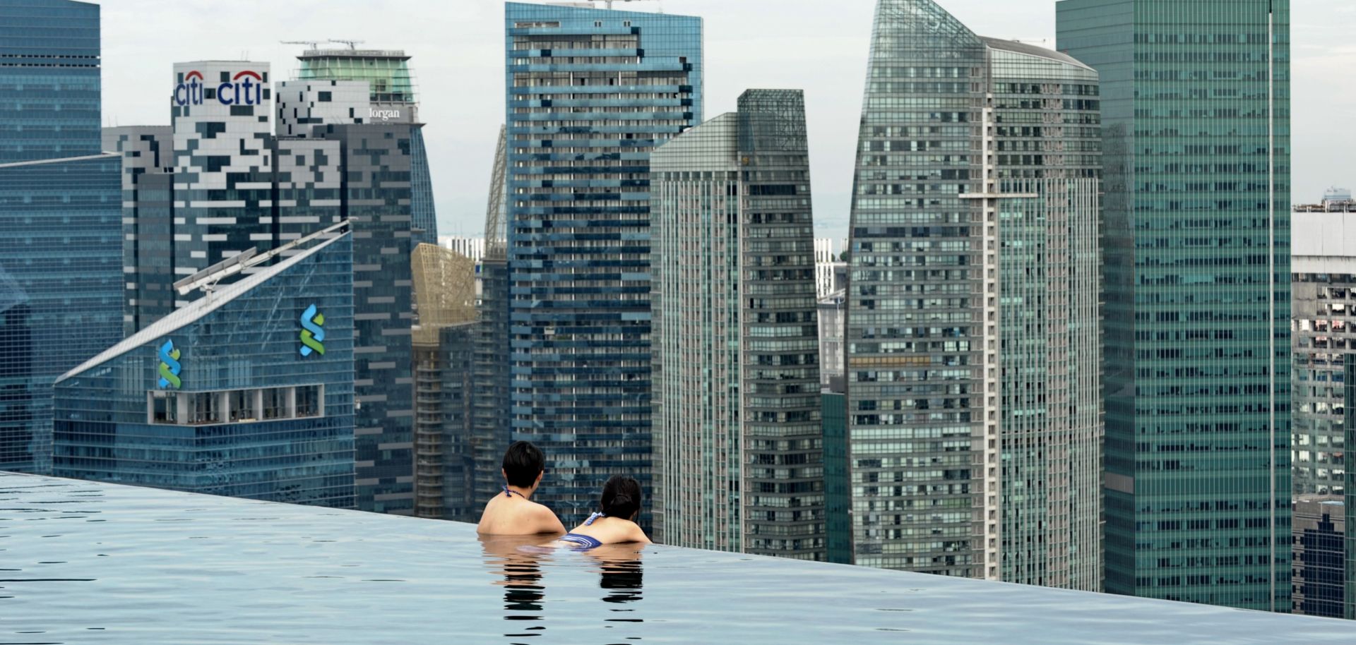 Tourists look at a view of the city skyline in Singapore.