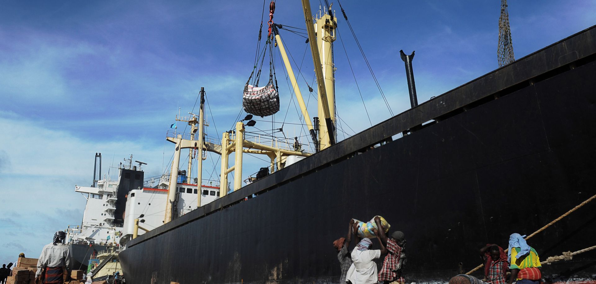 Porters carry goods offloaded from foreign ships docked at the harbor in Mogadishu on April 24, 2013. In Mogadishu's economic heart, Bakara market -- where a U.S. helicopter was shot down in 1993 in scenes made famous by the Hollywood film "Black Hawk Down" -- the scars of frontline fighting that raged less than two years ago have faded. Somalia, once a byword for war and anarchy, appears to be slowly turning a corner, with Islamist forces on the back foot despite launching a series of bloody guerrilla atta