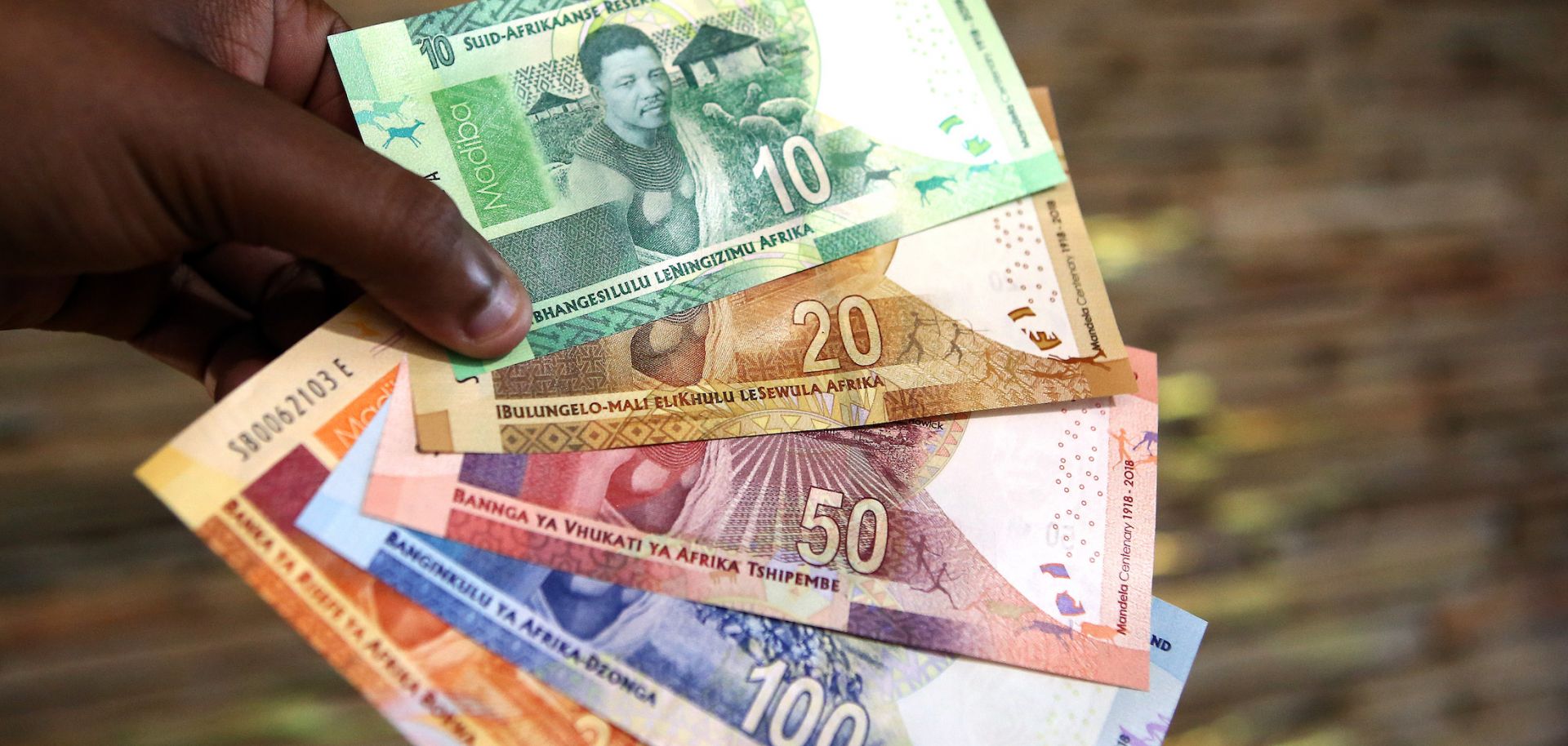 A man holds new South African banknotes of the South African rand on July 13, 2018, in Pretoria, South Africa. 