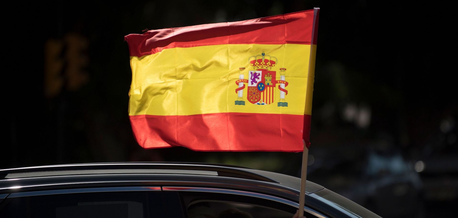 A driver waves a Spanish flag from his car during an anti-government demonstration organized by Spain's far-right Vox party in Malaga on Oct. 12, 2020. 