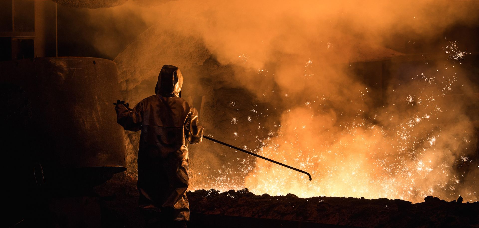 A worker in Germany oversees steel production while wearing protective gear. 
