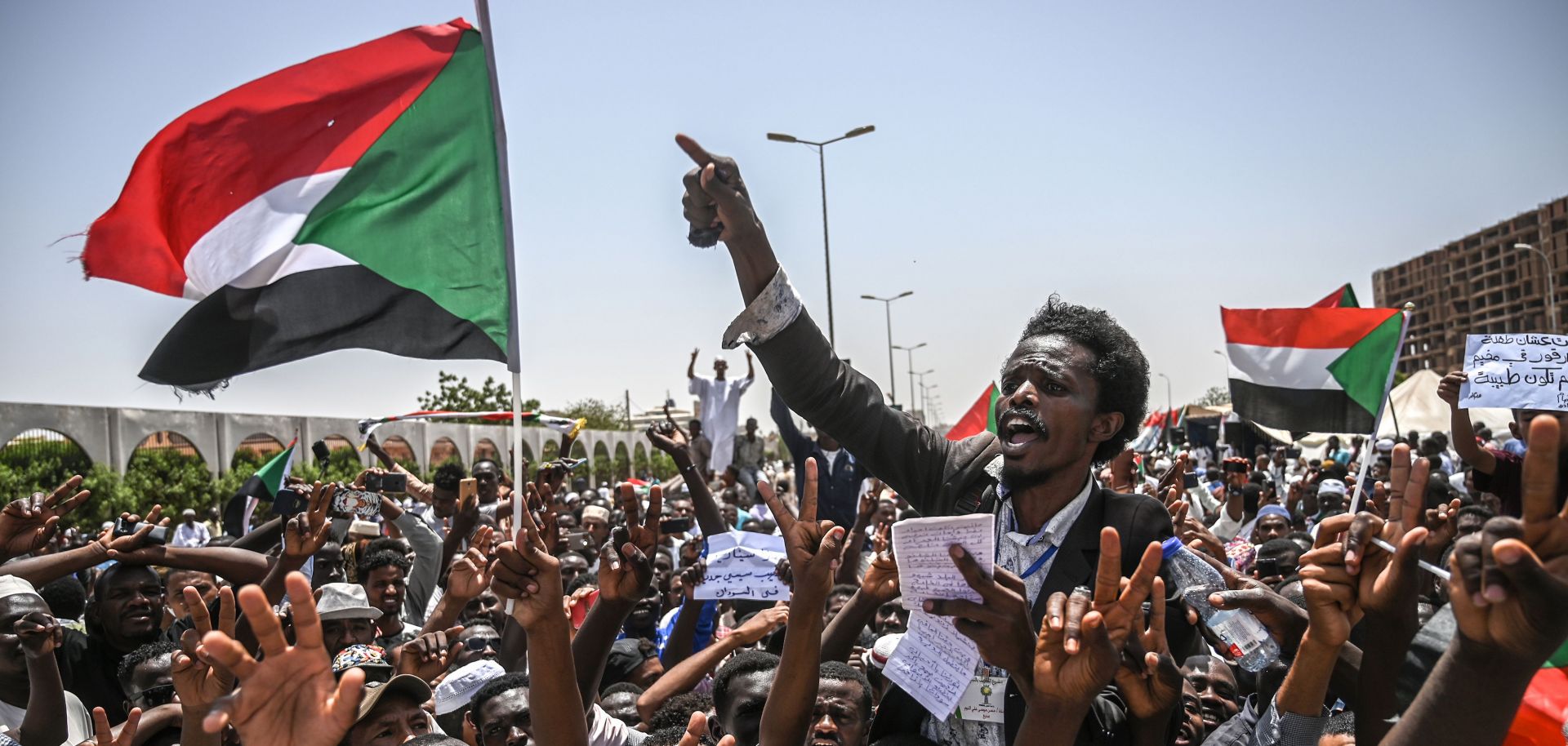 Sudanese protesters wave national flags and chant slogans during a sit-in outside the army headquarters in the capital of Khartoum, April 26. 