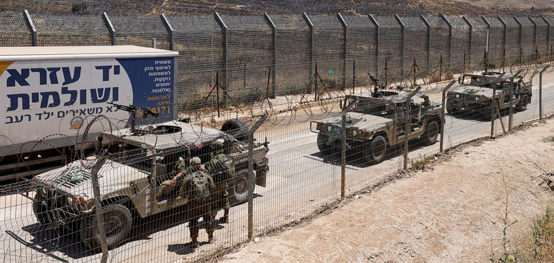 Israeli military vehicles drive along the border fence into Israel, near the town of Majdal Shams, in the Israeli-annexed Golan Heights, on July 17, 2025.