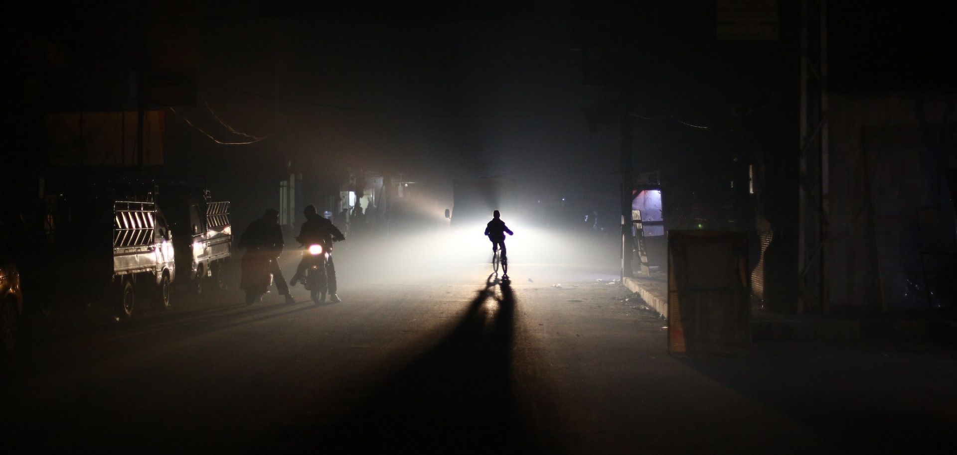 Residents of the besieged Syrian town of Douma ride through the street at night during an electricity shortage on Jan. 19, 2015.