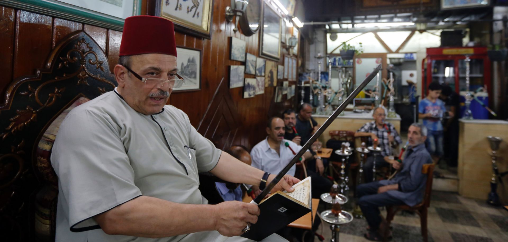 Syrian storyteller Ahmad al-Lahham reads from his book at a coffeehouse in Damascus. The Syrian culture is also alive and well in Amsterdam, where a bookstore features the country's visual and literary arts.