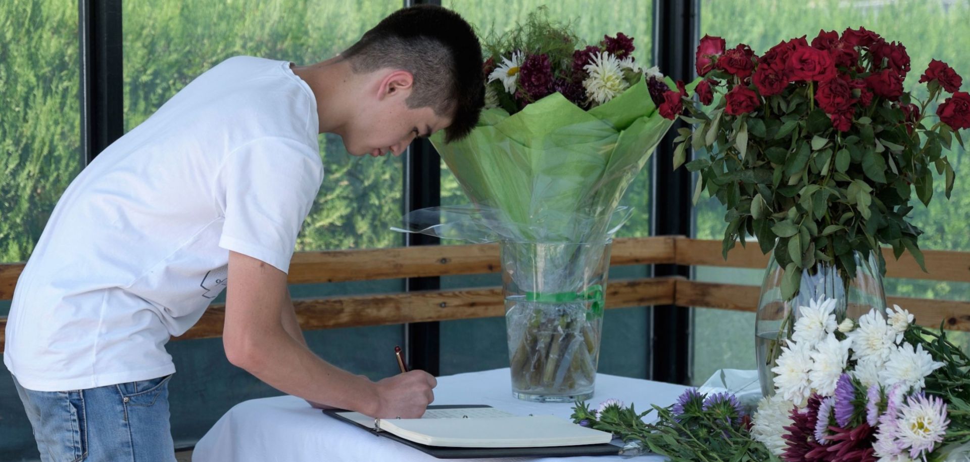 A man signs a condolence book at the U.S. Embassy in Dushanbe, Tajikistan, for the four bicyclists killed in a terrorist attack on July 29, 2018.