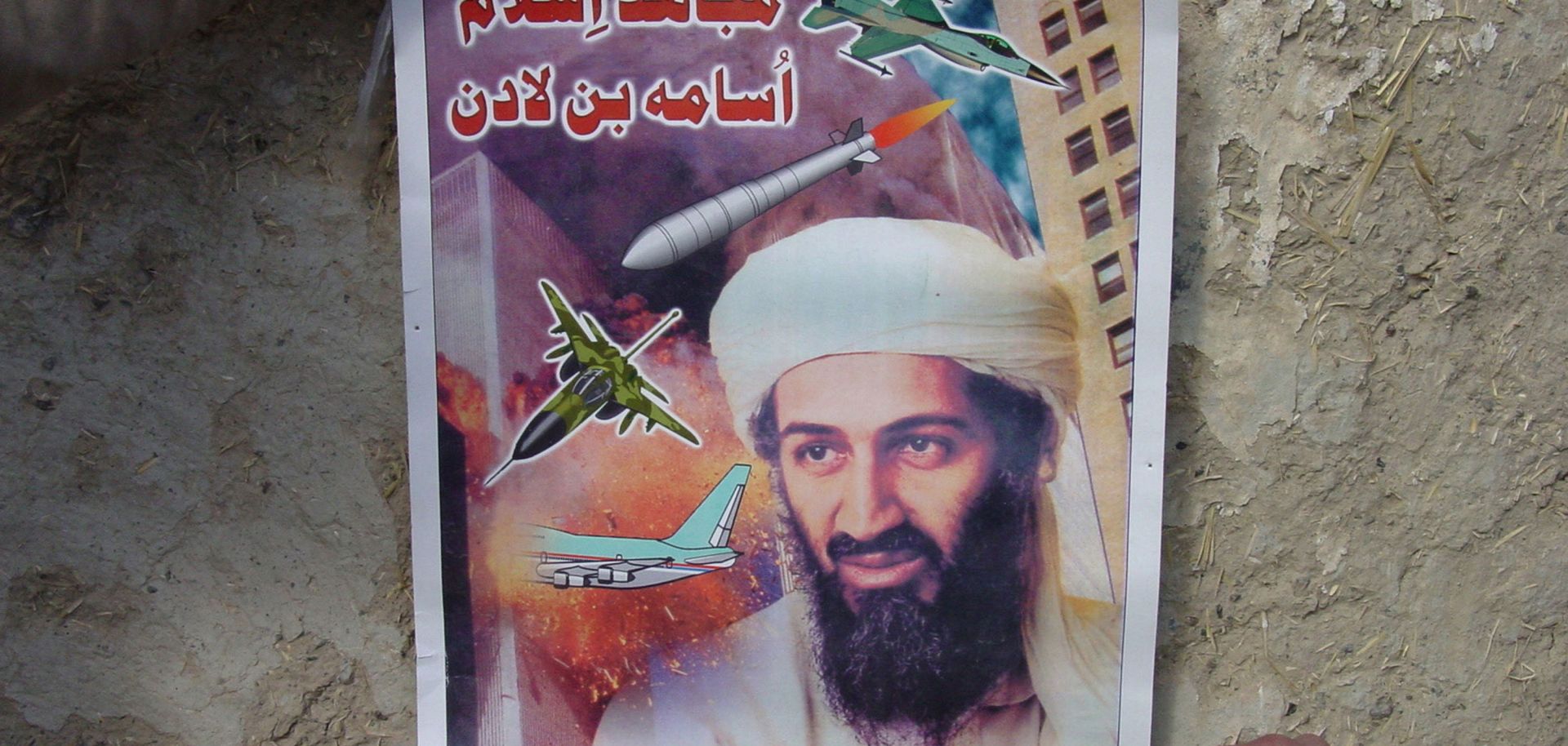 A poster found in an al Qaeda classroom shows Osama Bin Laden smiling and surrounded by military vehicles.