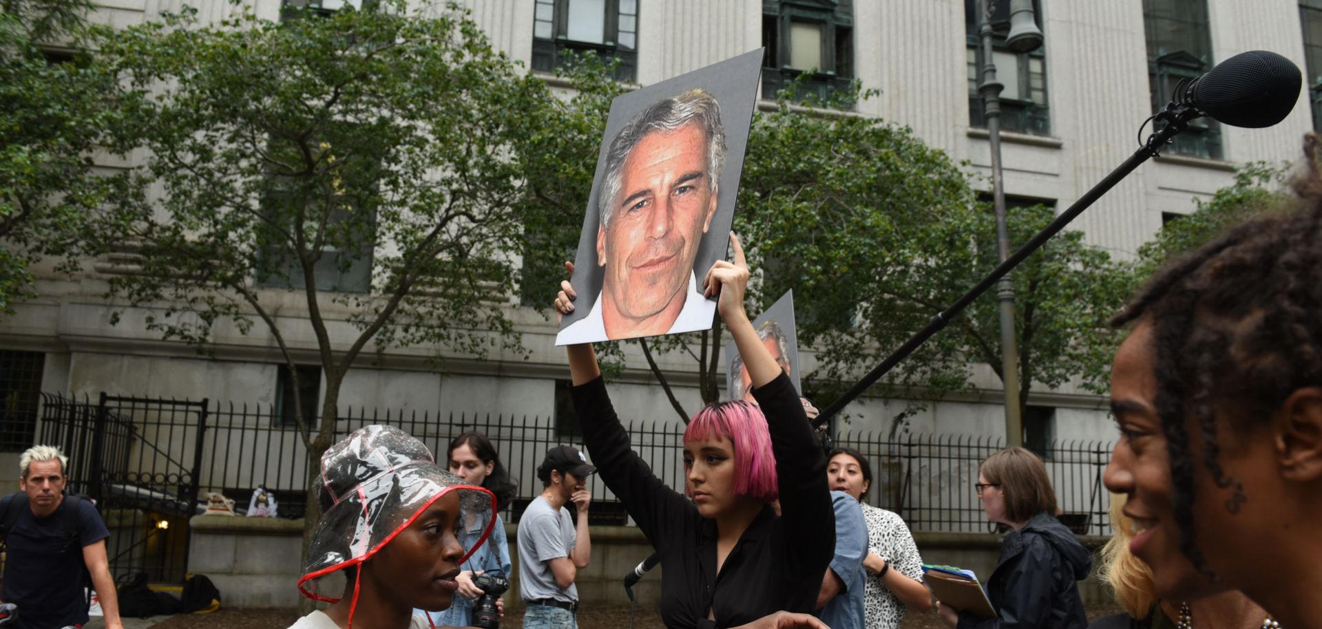A protest group called Hot Mess holds up signs of Jeffrey Epstein at the federal courthouse in New York City on July 8, 2019.