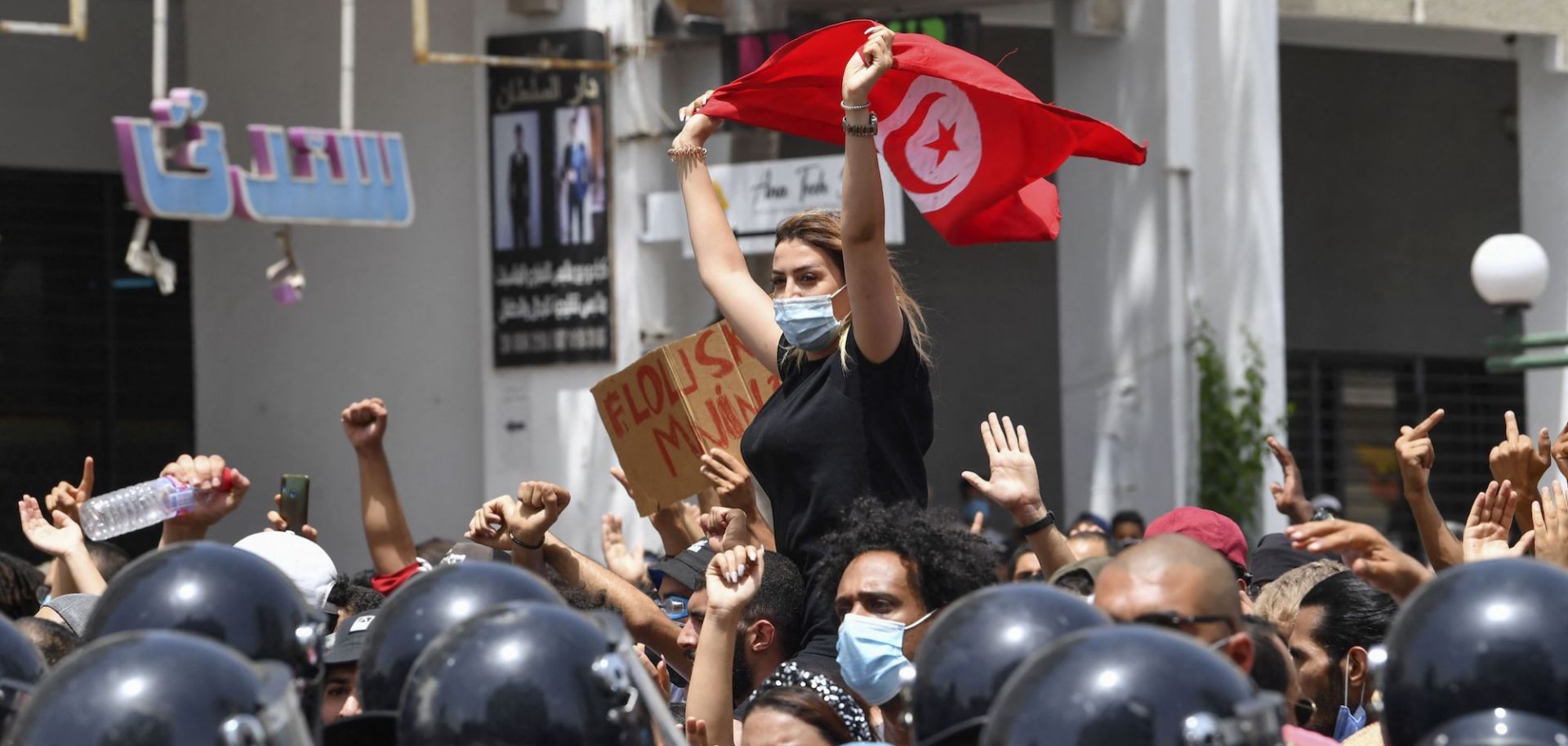 A protester lifts a Tunisian flag at an anti-government rally in Tunis on July 25, 2021.