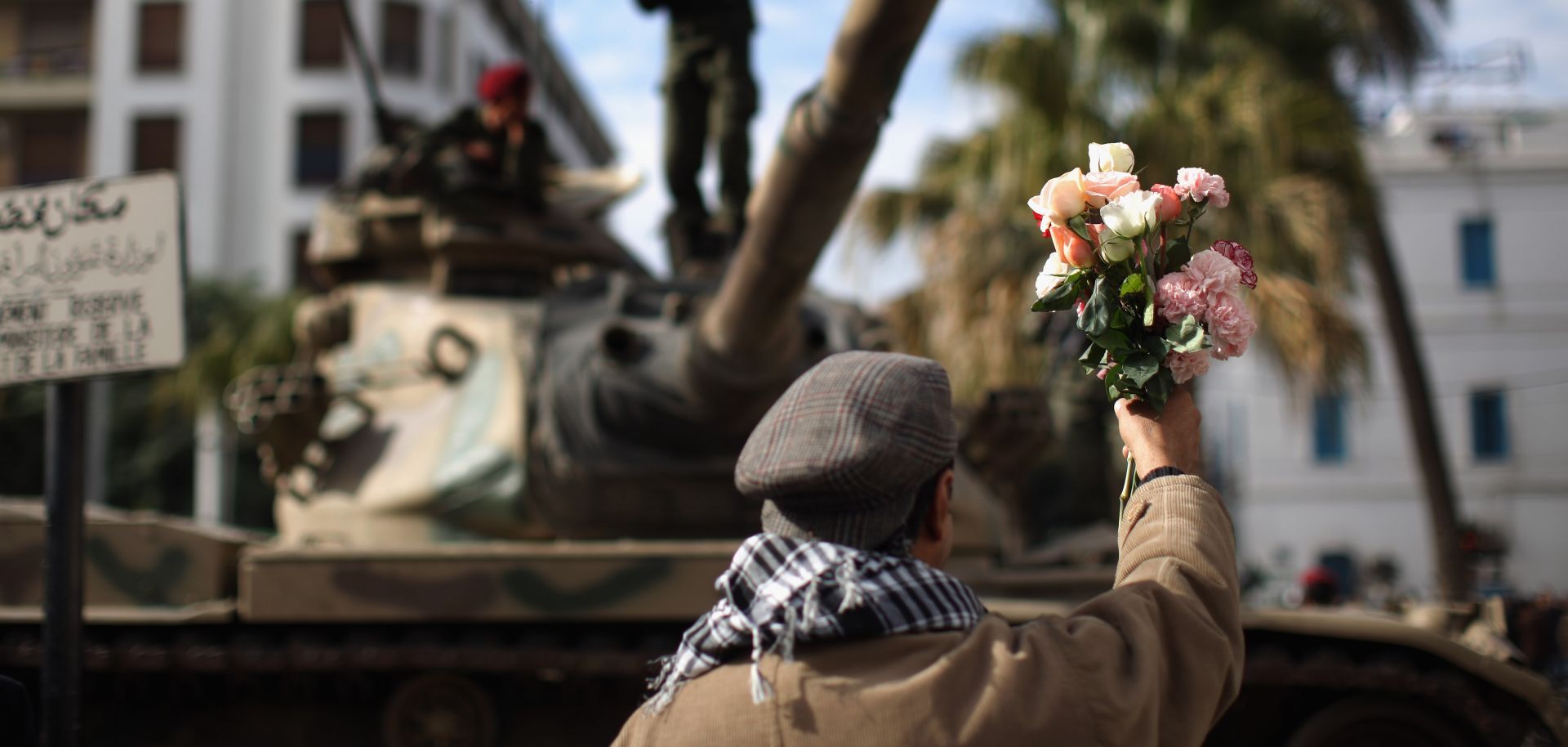 A demonstrator offers flowers to soldiers on Jan. 21, 2011, in Tunis during a three-day period of mourning for the people who died during the country's revolution.