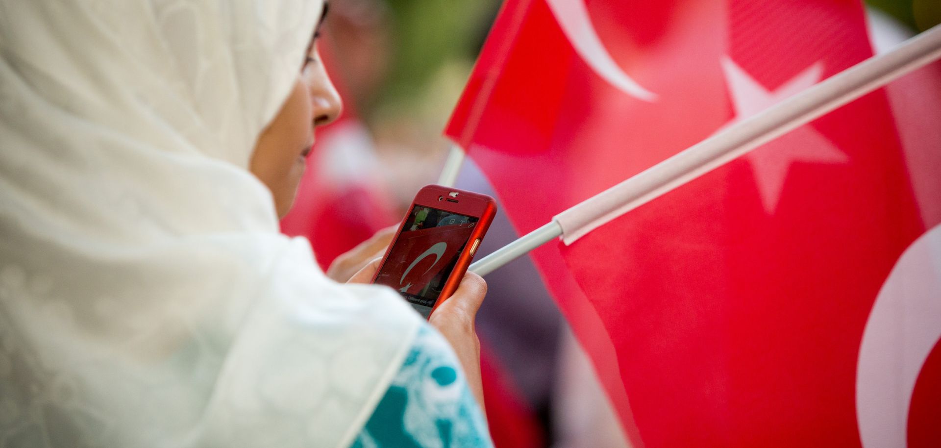 A woman shares a photo of the Turkish flag on social media during a protest in Washington D.C. on July 15, 2016. 