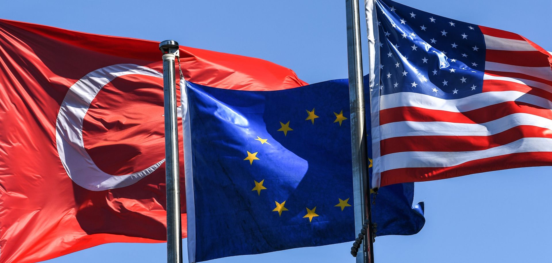 (From L) The Turkish flag, the European Union's flag and the U.S. flag float in the wind at the financial and business district Maslak on Aug. 15 in Istanbul. 