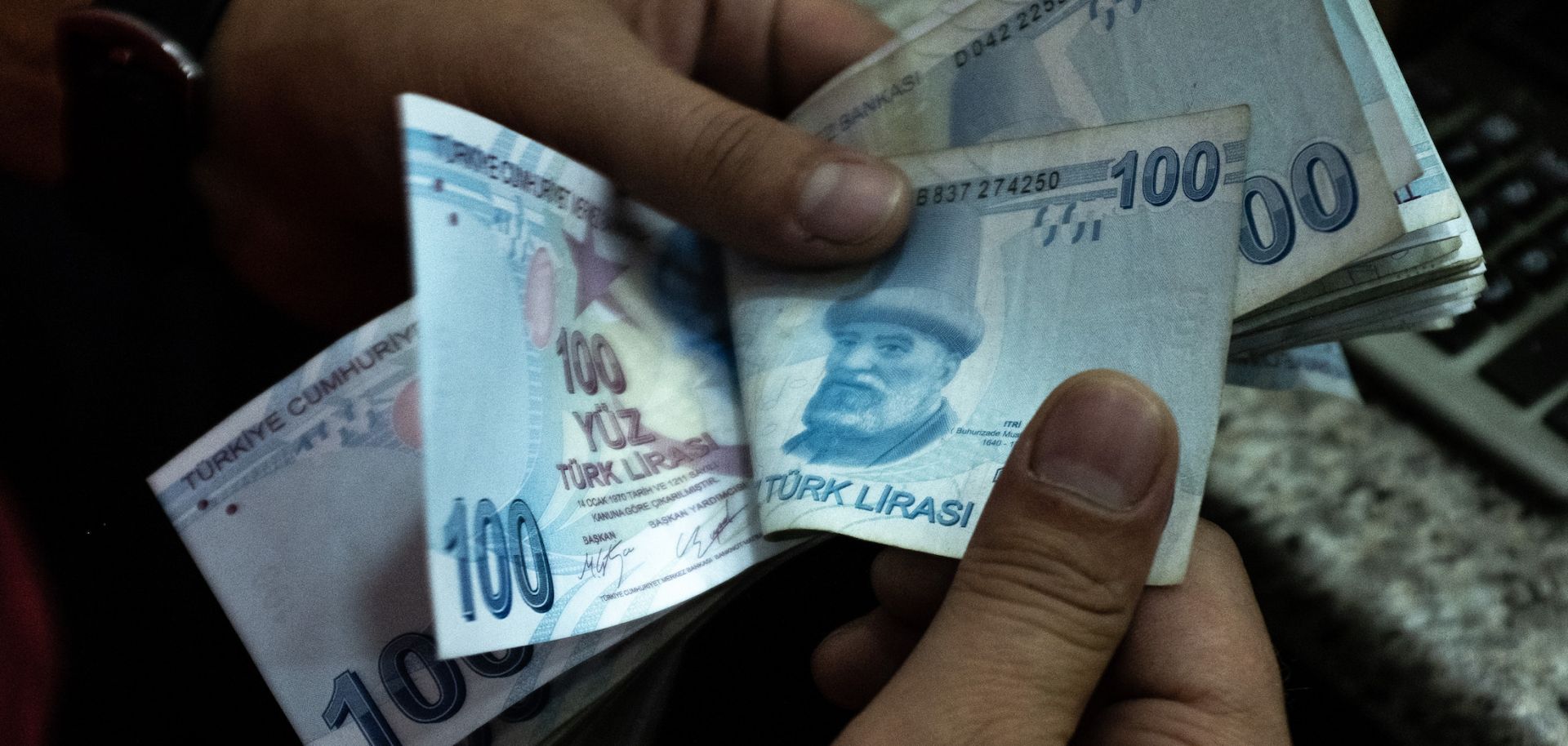 A man counts Turkish lira at a currency exchange office July 29, 2020, in Istanbul.