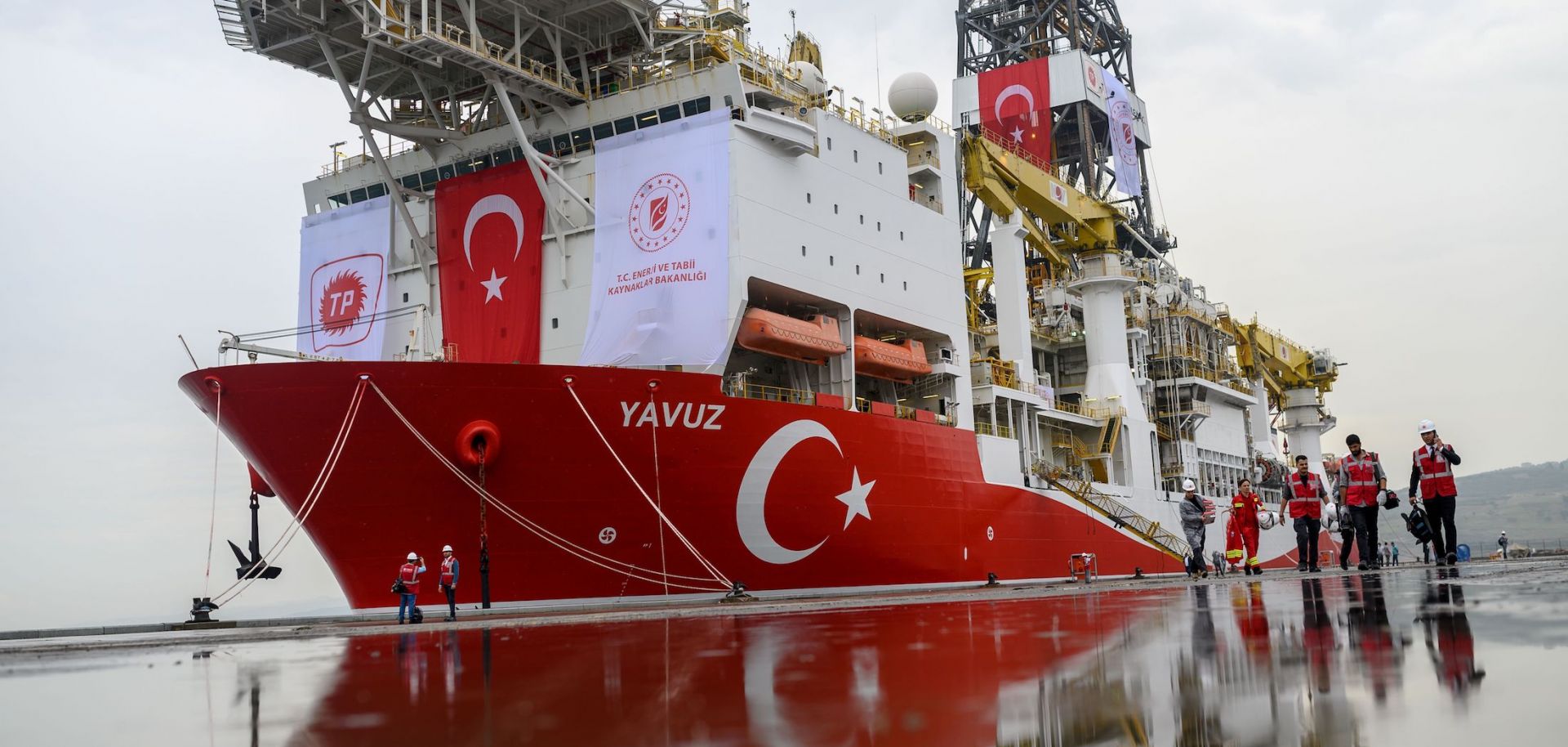 Journalists walk next to the Turkish drilling ship 'Yavuz,' scheduled to search for oil and gas off Cyprus, at the port of Dilovasi, outside Istanbul, on June 20, 2019.