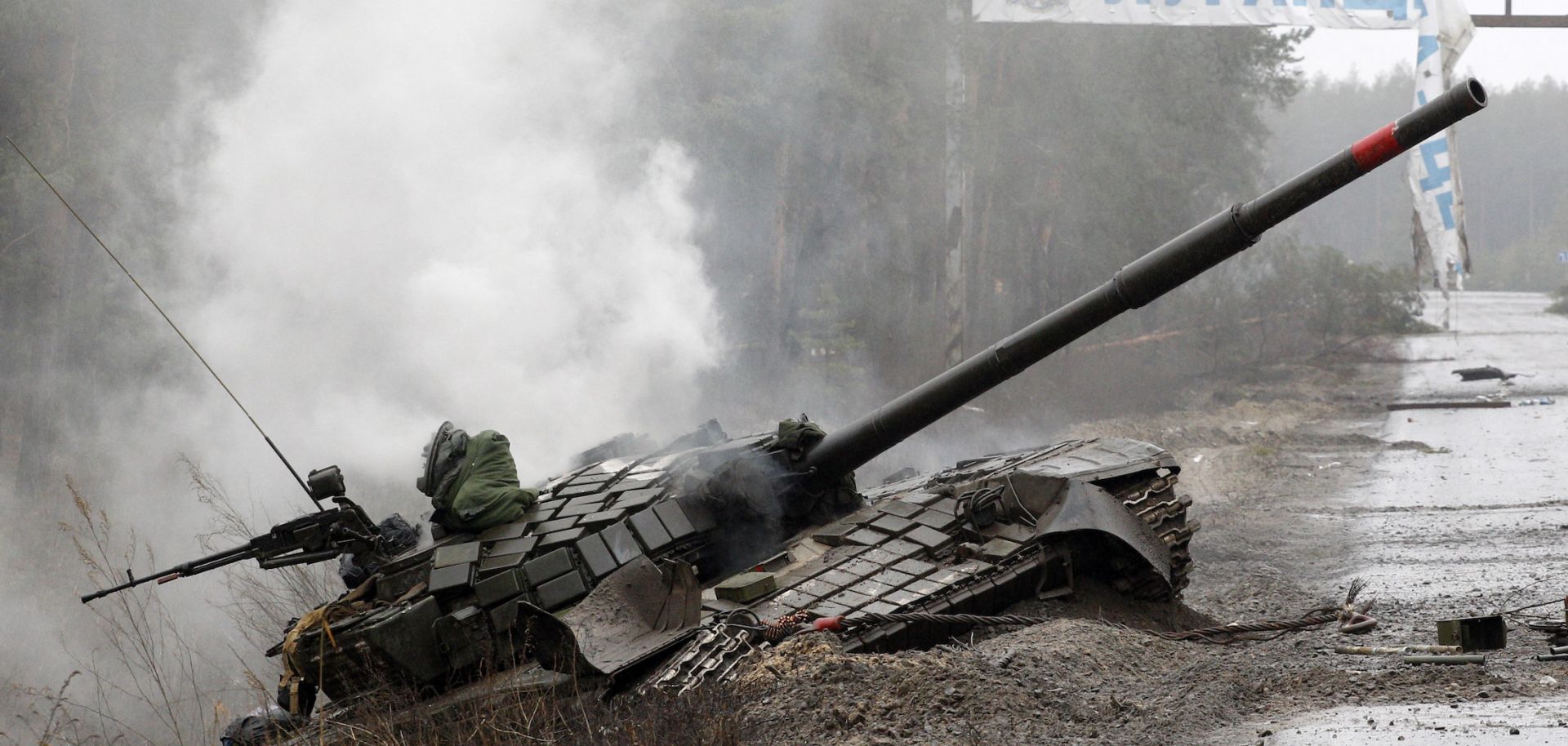 Smoke rises from a Russian tank destroyed by the Ukrainian forces on the side of a road in Lugansk region
