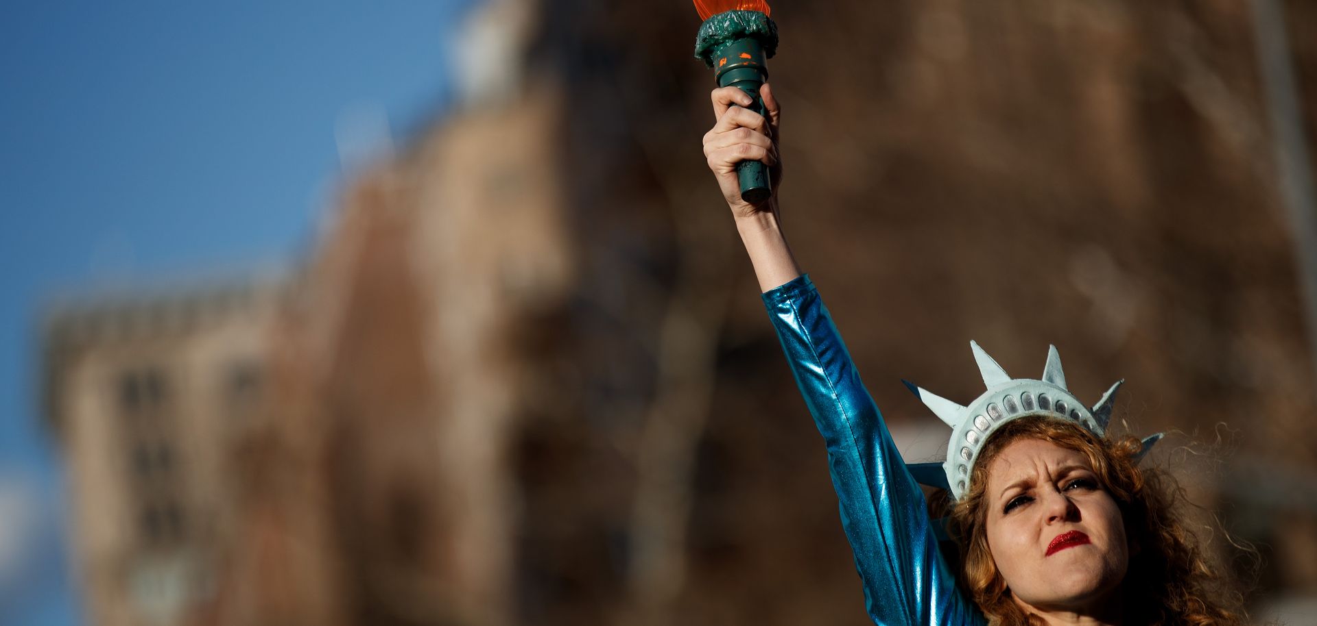 A young woman takes to the stage dressed as the Statue of Liberty for a demonstration on International Women's Day in New York City.
