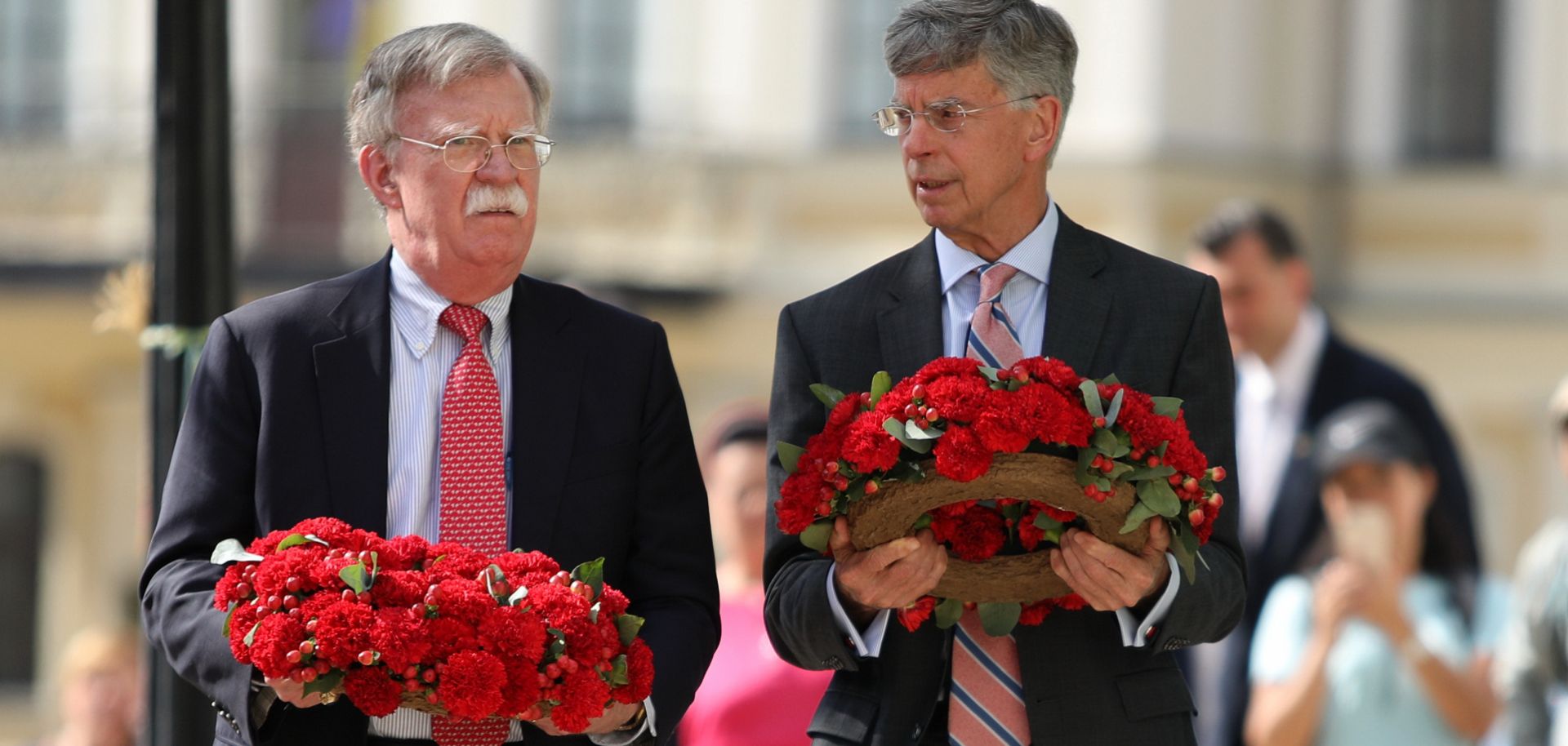 U.S. national security adviser John Bolton (L) and U.S. Ambassador to Ukraine William Taylor prepare to lay flowers commemorating Ukrainian soldiers who died in eastern Ukraine during a visit to Kyiv on Aug. 27, 2019.