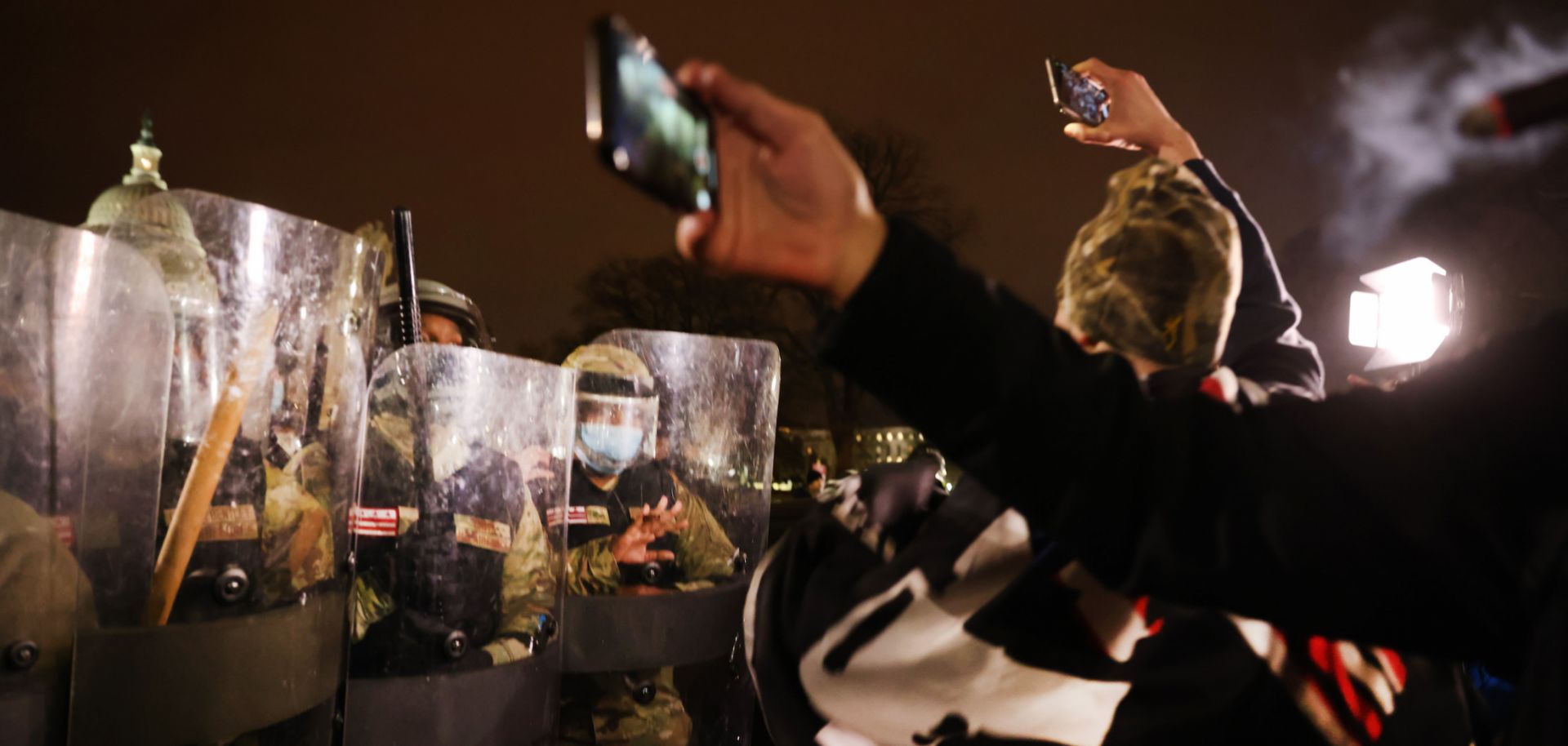 Members of the National Guard and the District of Columbia police keep a small group of protesters at bay after thousands of Trump supporters stormed the Capitol building following a 'Stop the Steal' rally on Jan. 6, 2021, in Washington.