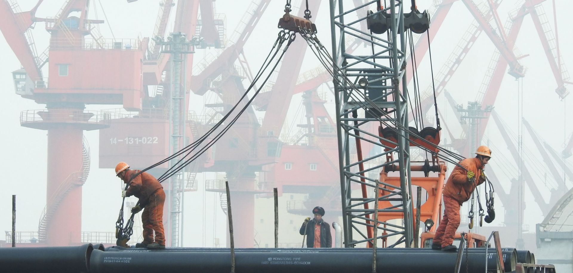 Chinese workers prepare to load pipes onto a ship in the port of Lianyungang on Jan. 14, 2019.