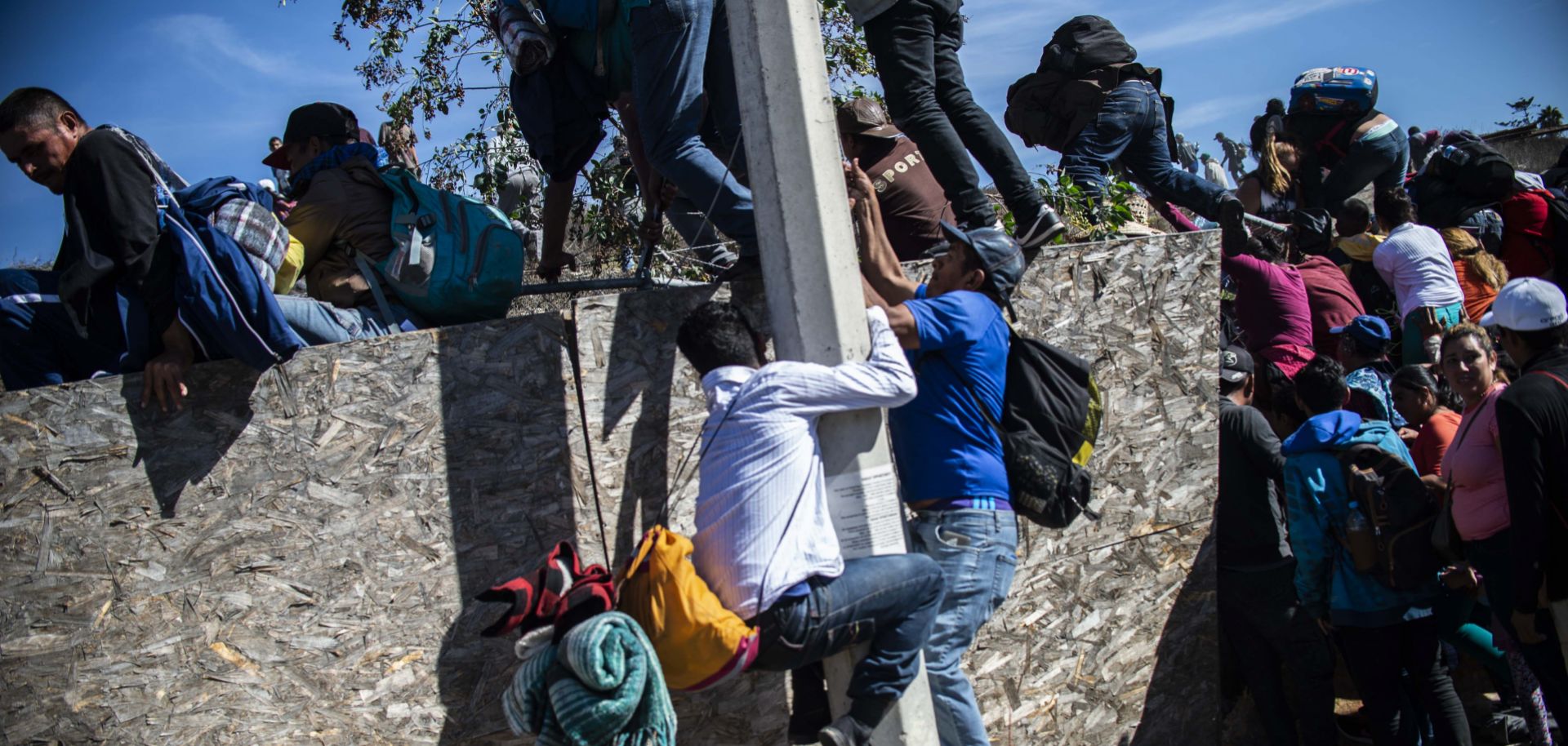Central American migrants, mostly from Honduras, climb over a barrier as they try to reach the U.S.-Mexico border on Nov. 25, 2018, near the El Chaparral border crossing in Tijuana, Baja California State, Mexico.