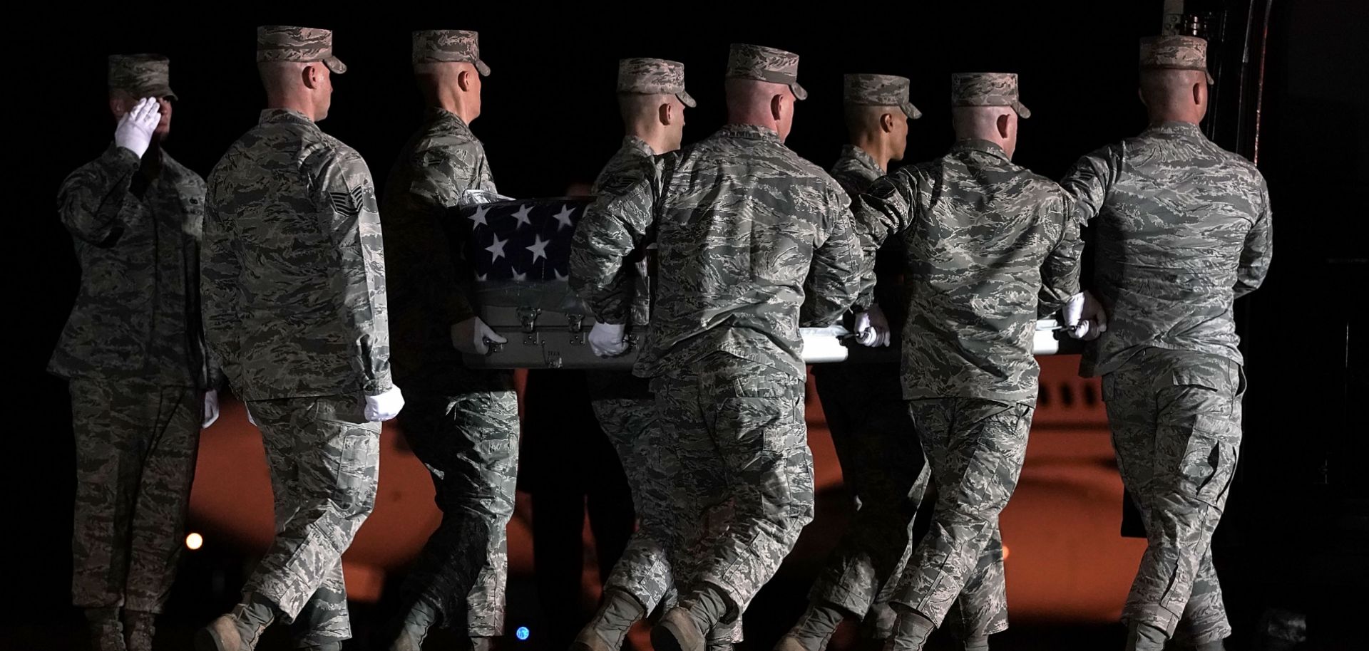 In this March 18, 2018, file image, members of the U.S. Air Force carry the flag-draped transfer case holding the remains of Air Force Master Sgt. Christopher Raguso of Commack, New York, at Dover Air Force Base in Delaware. Raguso was killed in a helicopter crash in western Iraq.