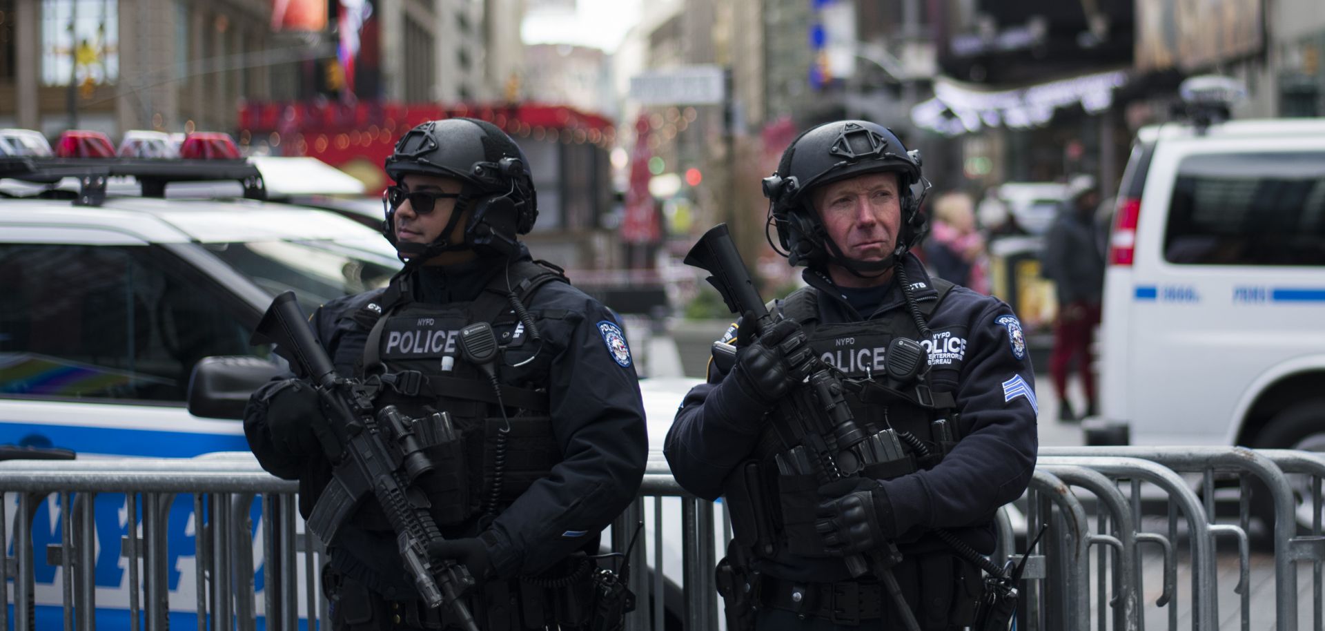 Two police officers in New York City carry rifles during a ceremony for the reopening of the Times Square Military Recruiting Station. 