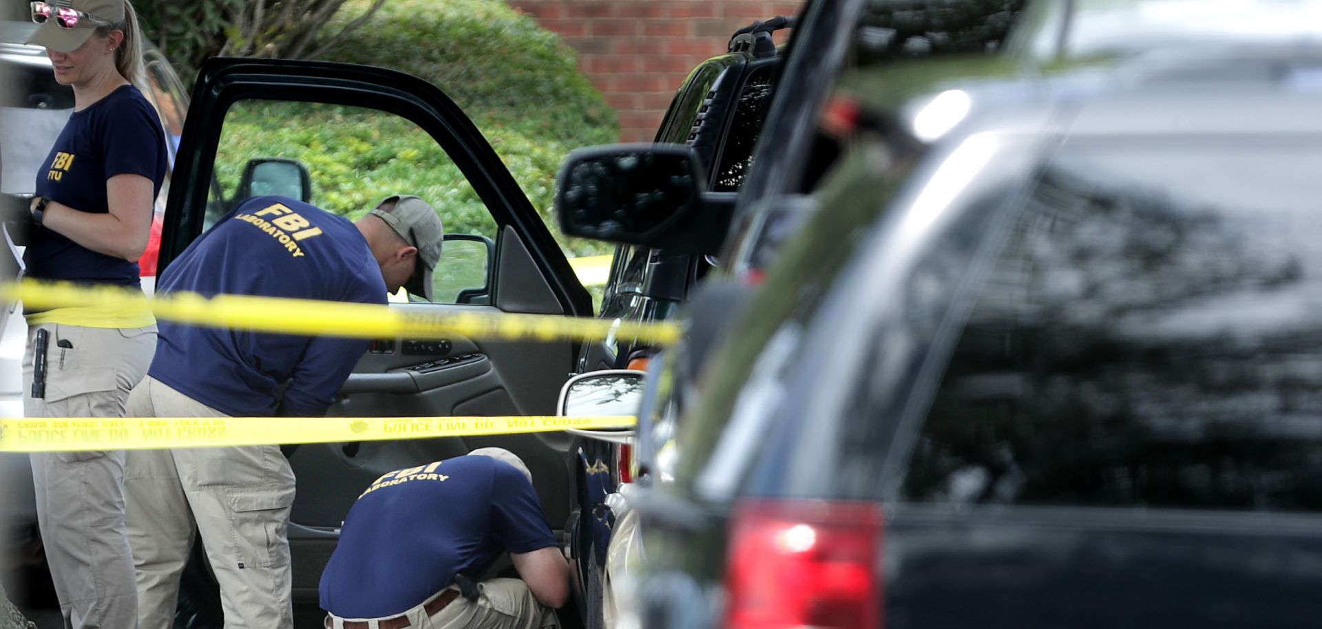 Crime scene experts from the FBI remove evidence from a black SUV on the day after a mass shooting at the Virginia Beach Municipal Center on June 1, 2019.