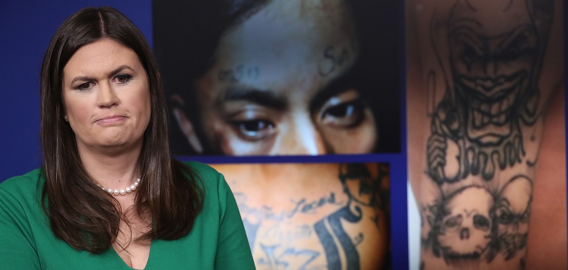 White House Press Secretary Sarah Huckabee Sanders stands in front of photos from the MS-13 gang during a White House daily briefing July 27, 2017.