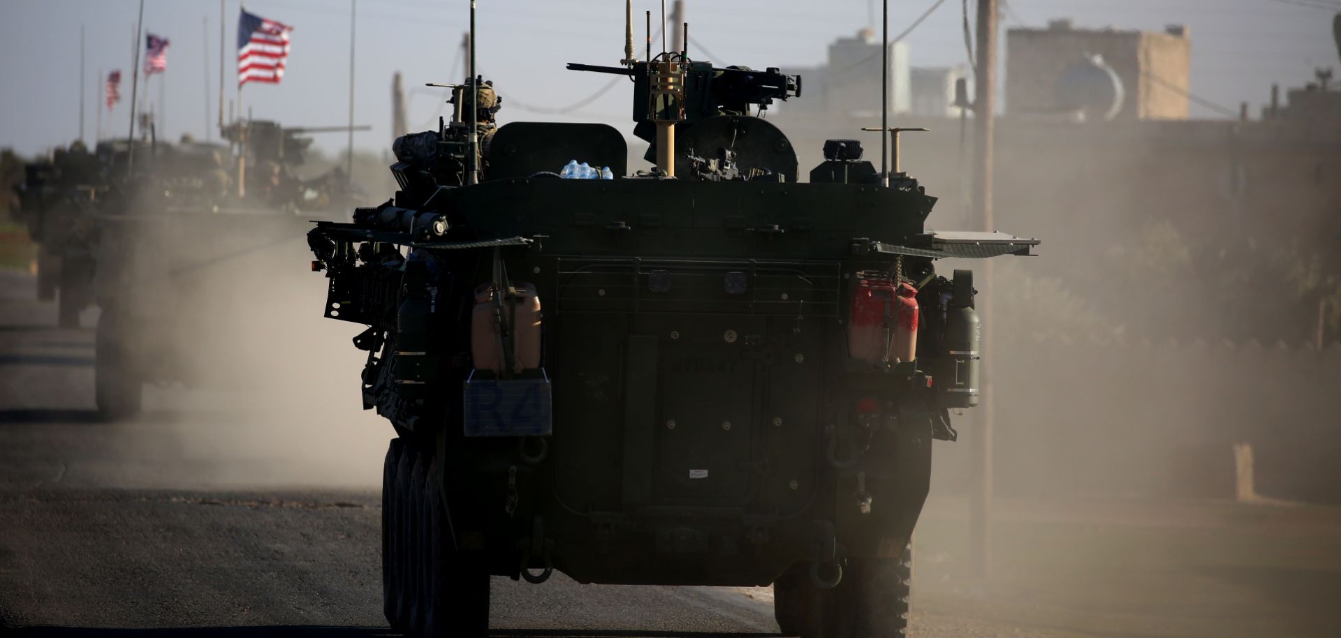 A convoy of U.S. armored vehicles passes through a village near Manbij, Syria, during March 2017.