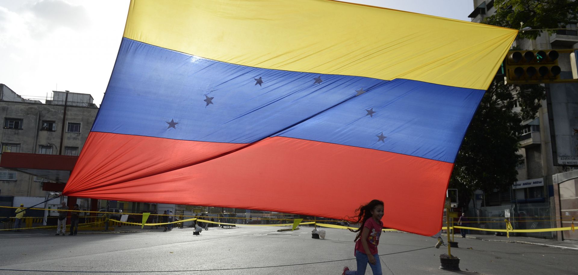 In the streets of Caracas, a girl plays near a Venezuelan flag in July 2017.