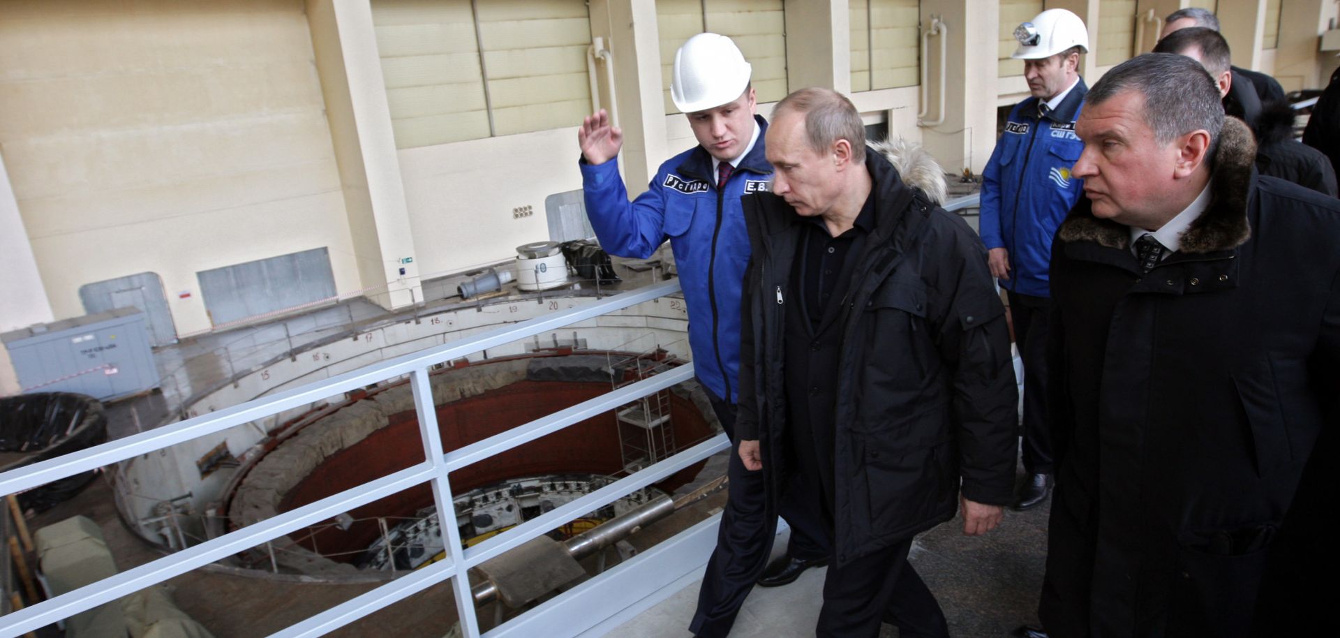 Vladimir Putin walks alongside workers at a hydroelectric plant.