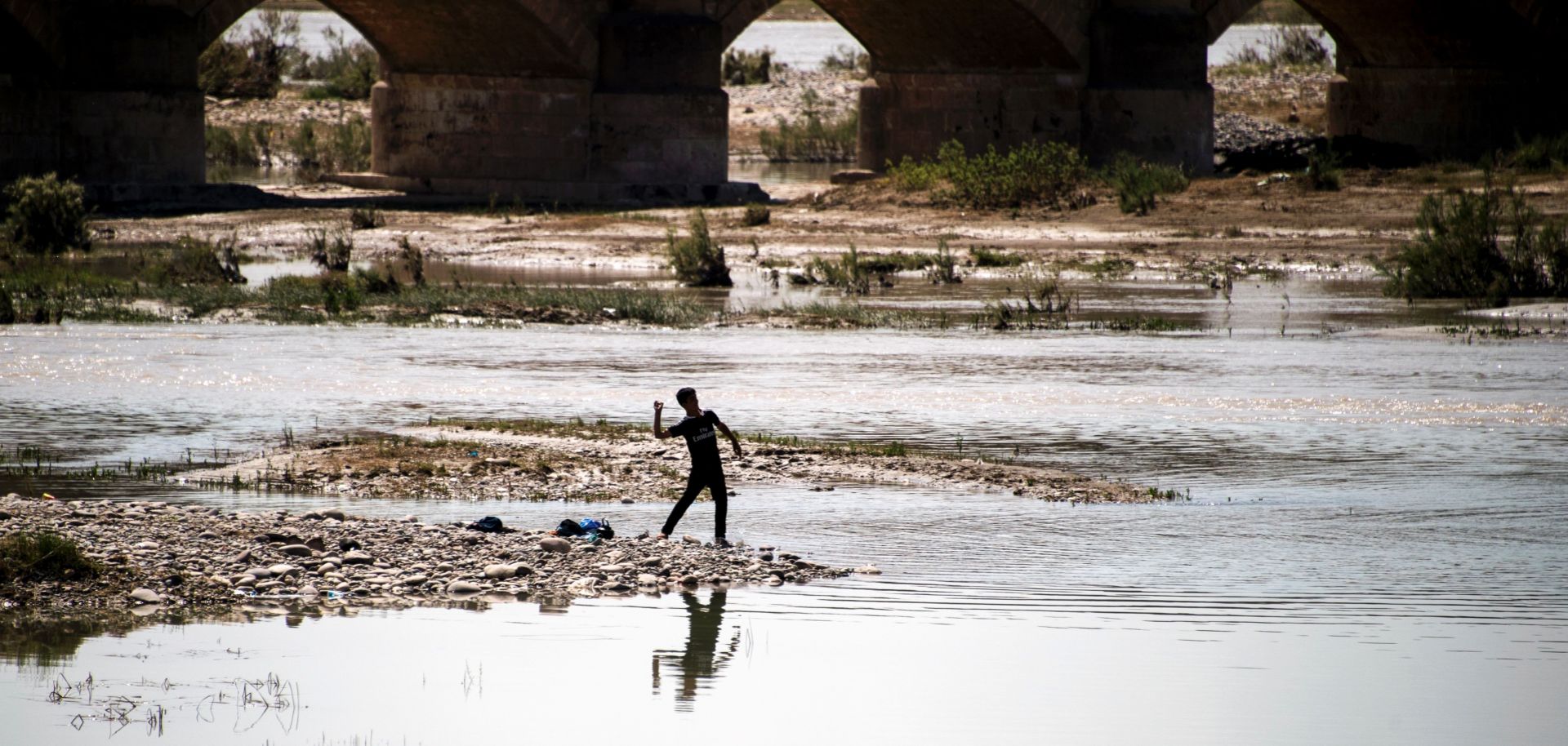 A boy throws a stone into a river near Arbil, the capital of Iraqi Kurdistan.