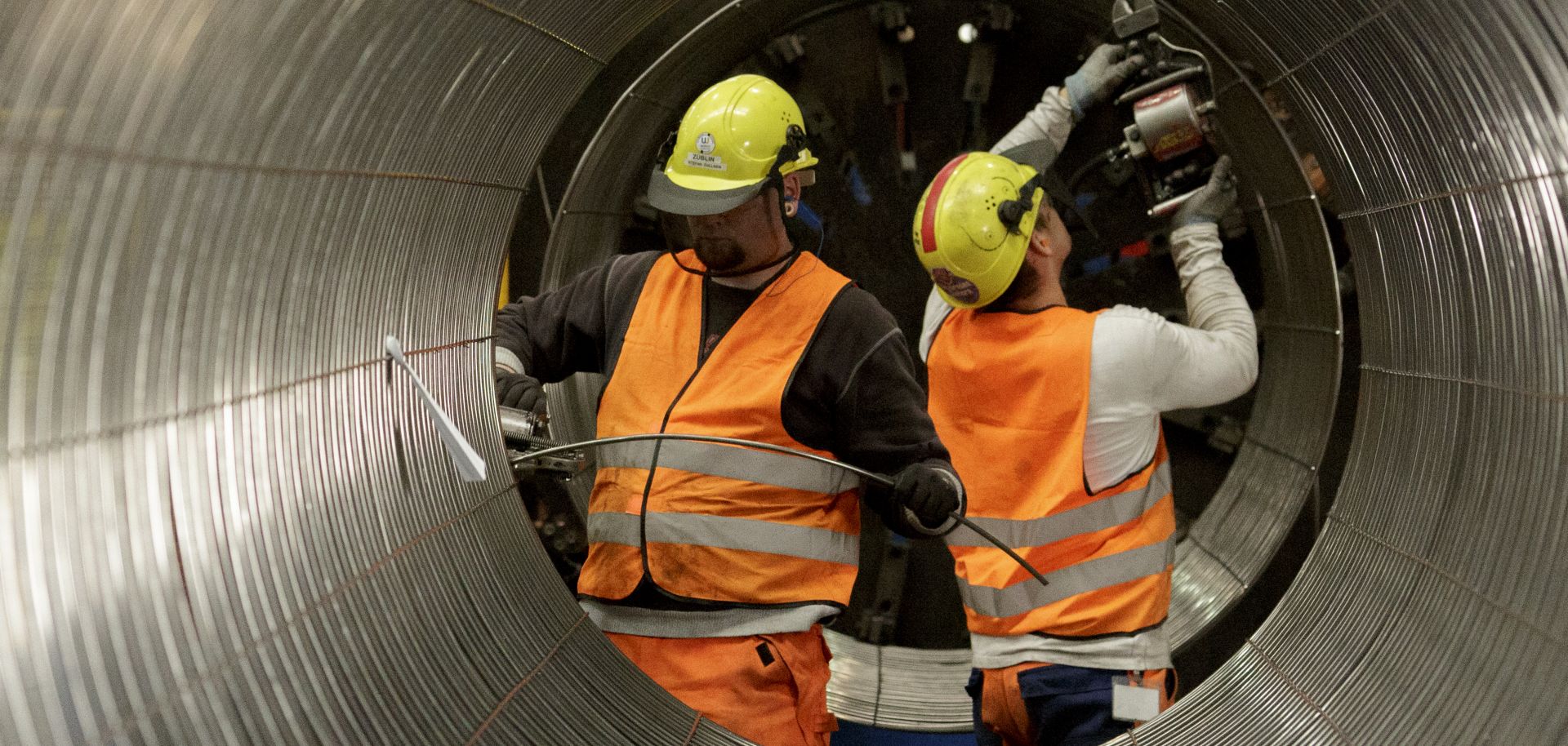 Workers construct an iron cage.