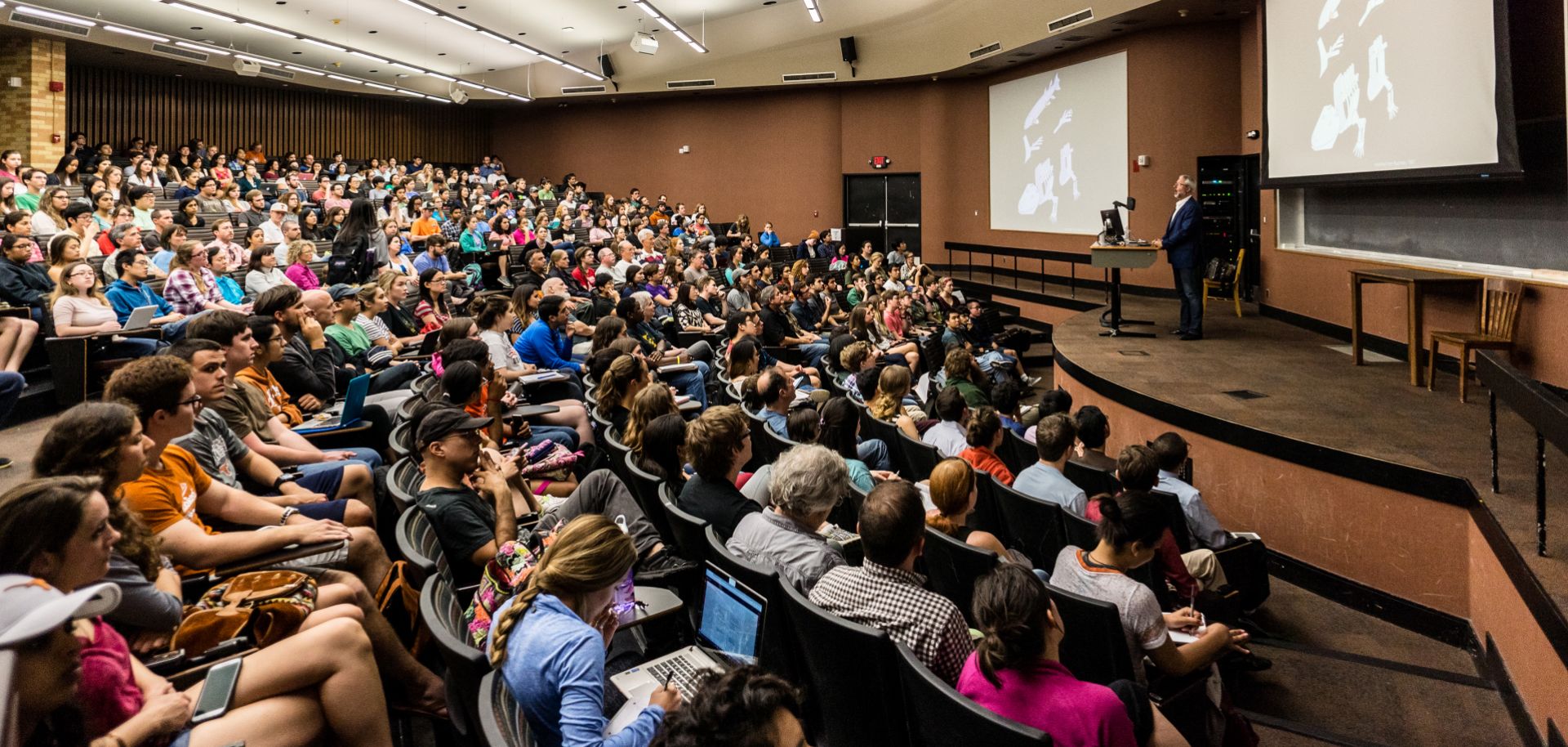 University students in an auditorium listen to their lecturer. Despite the success of the modern university, increasing numbers of people seem to see academically free universities as a luxury they no longer wish to support.