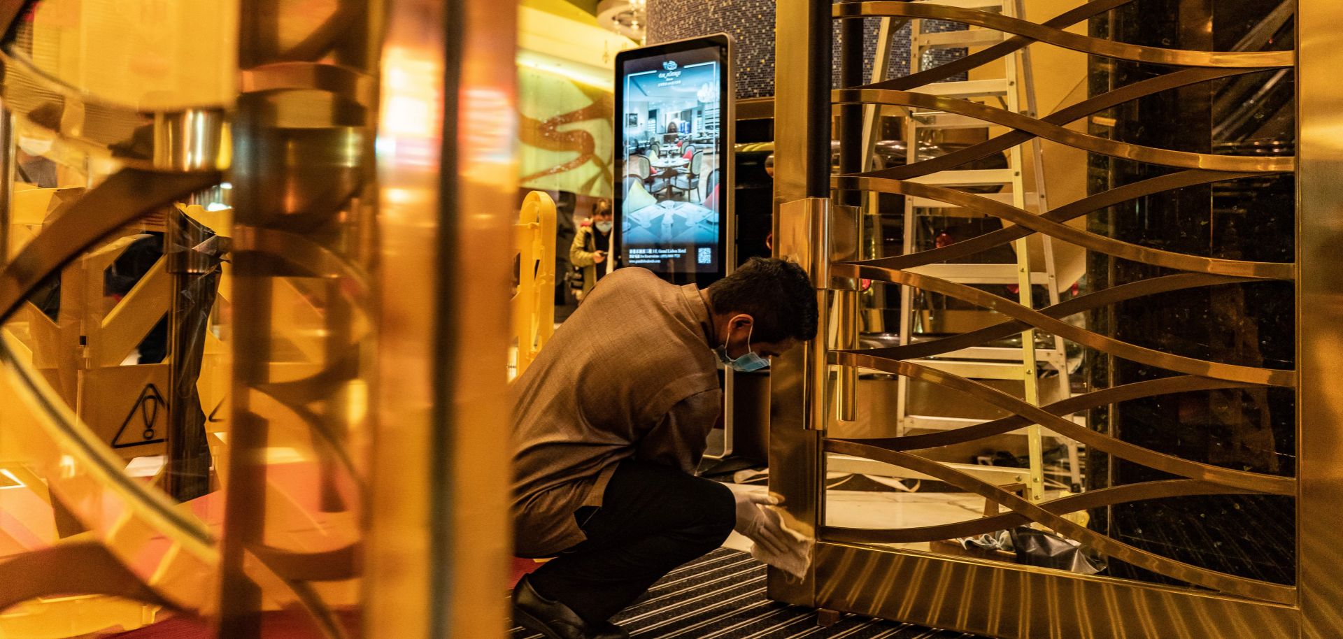 An employee cleans a door at the entrance of the Grand Lisboa Hotel in Macau on Feb. 5, 2020. 