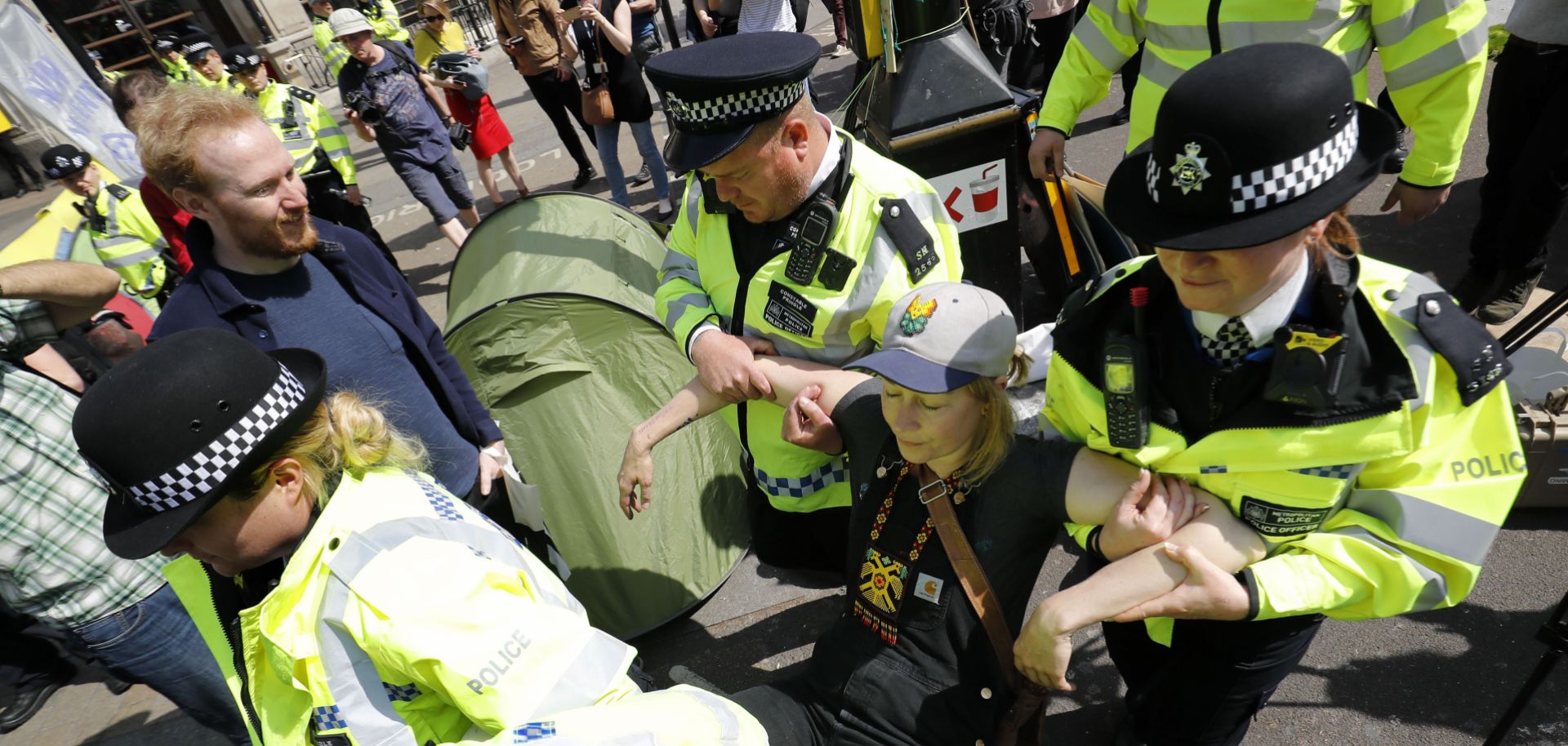 Police officers carry away an activist during an Extinction Rebellion protest in central London on April 19, 2019.