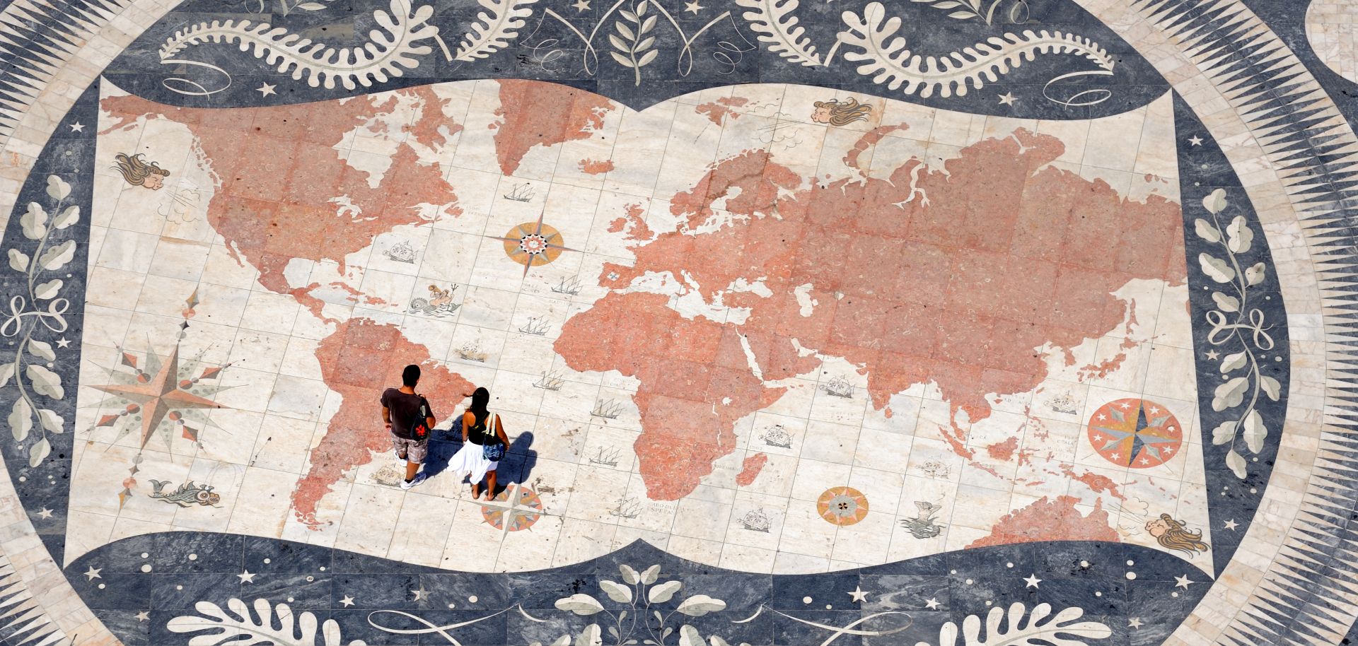 People stand over a world map at the Monument to the Discoveries in the Belem parish of Lisbon, Portugal, on Aug. 21, 2014.
