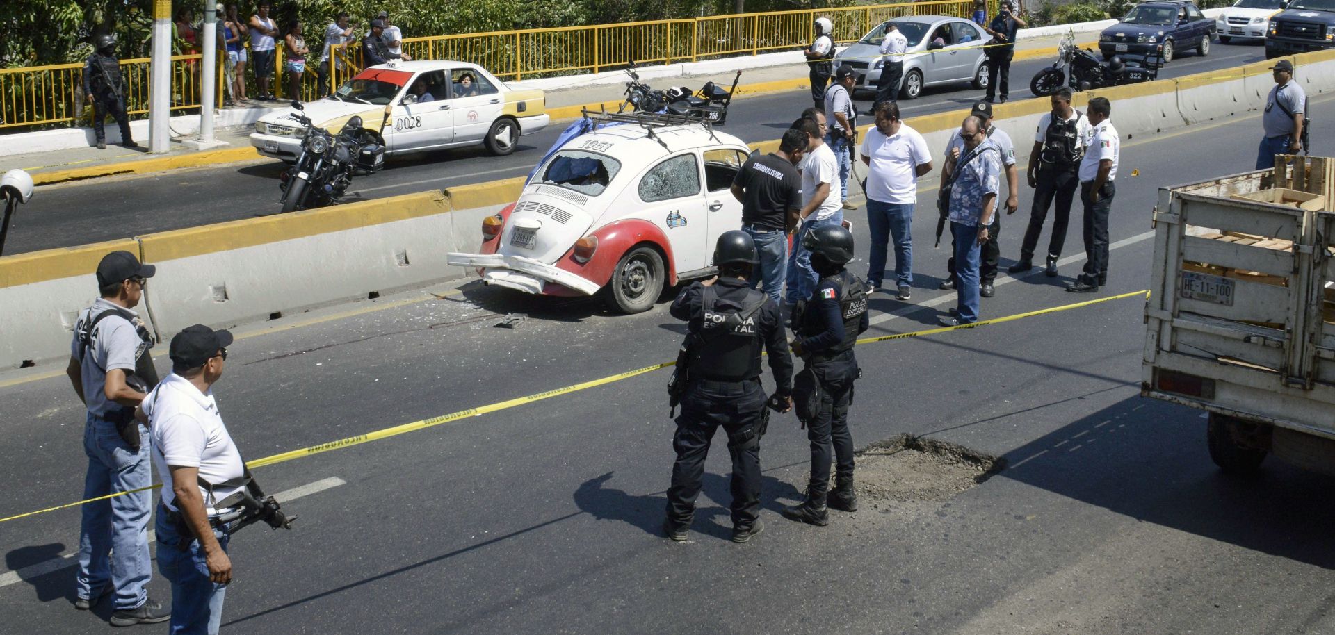 Authorities work at the scene where four racketeering suspects where shot down by security forces during a shoot-out along a highway in Acapulco in Guerrero on March 30, 2019.
