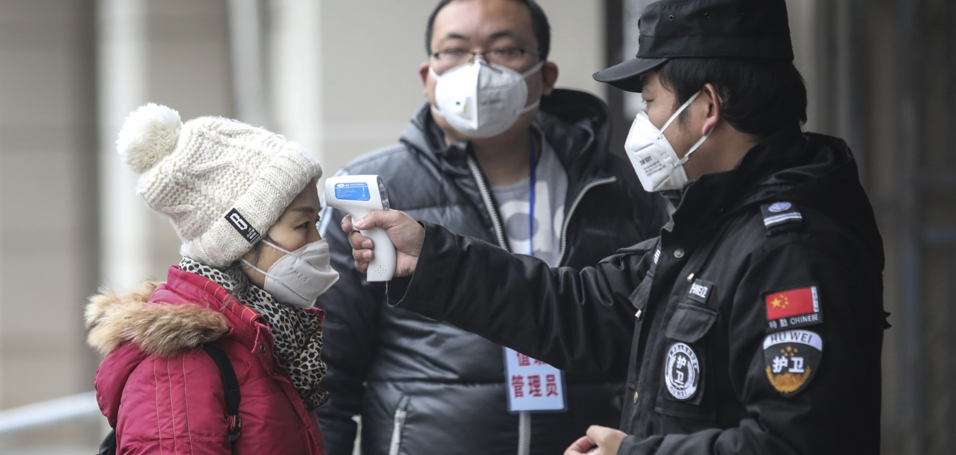 Authorities in Wuhan, China, check the temperature of a passenger at a wharf on the Yangtze River on Jan. 22, 2020.
