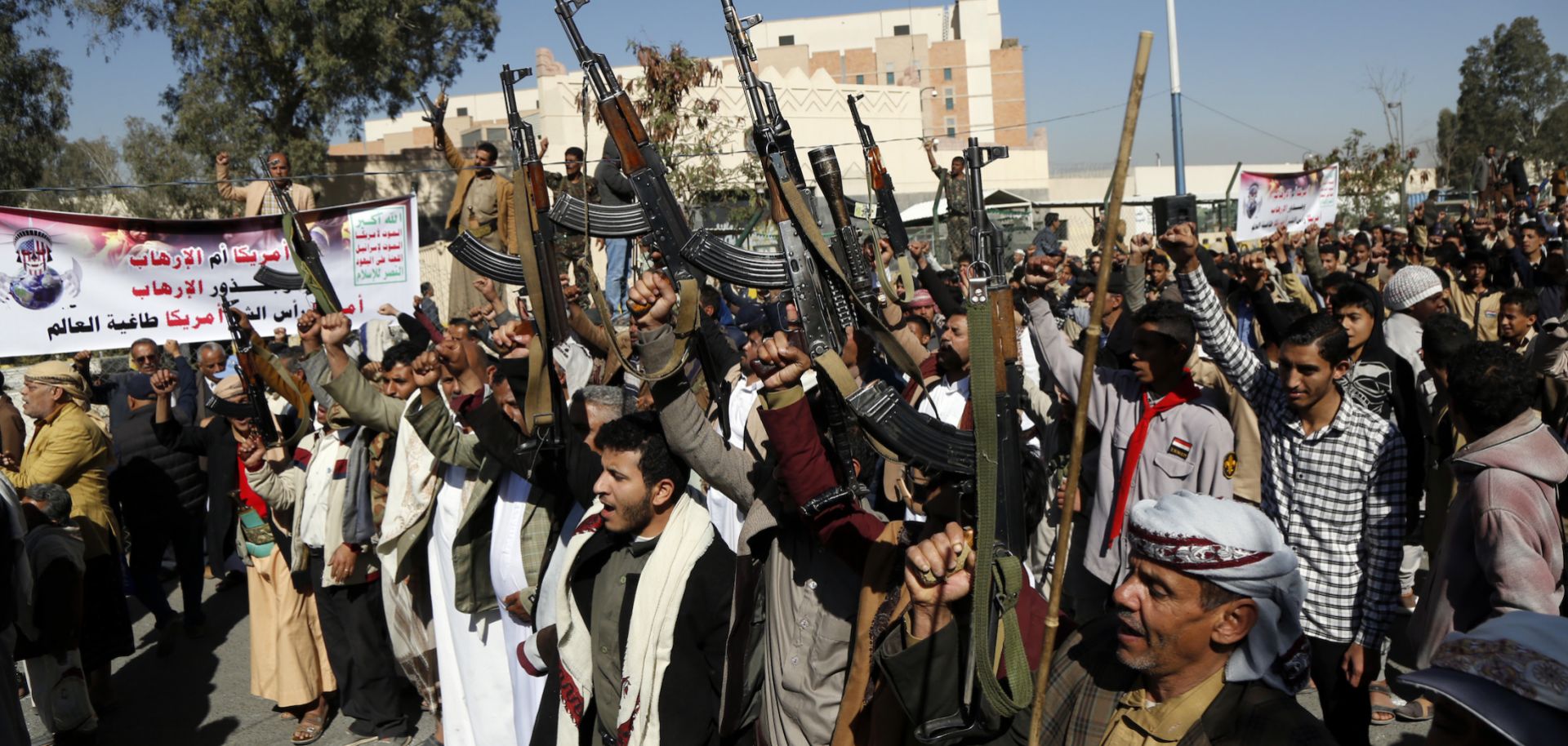 Houthi supporters hold up firearms as they protest the U.S. decision to designate the Houthi movement as a terrorist organization outside the closed American embassy on Jan. 18, 2021, in Sana'a, Yemen.  
