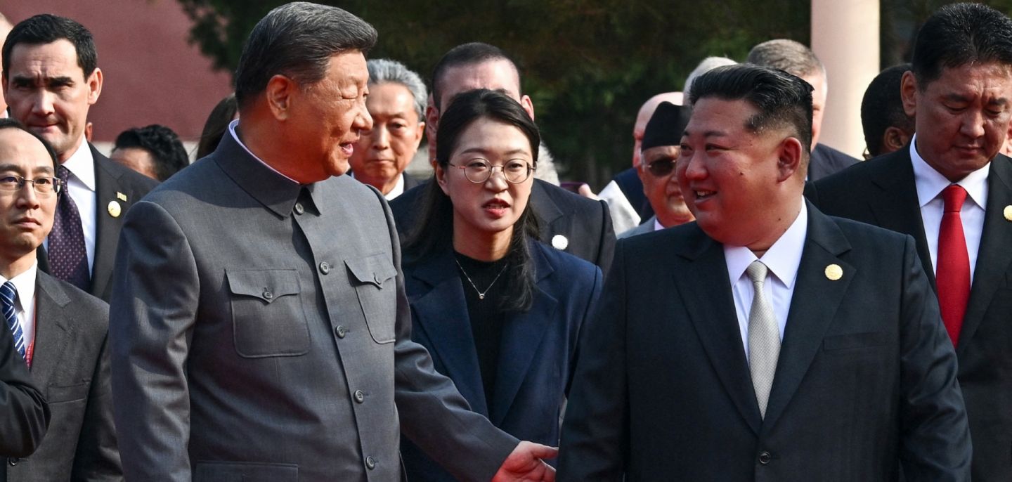 Chinese President Xi Jinping (left) gestures to North Korean leader Kim Jong Un before a military parade in Beijing's Tiananmen Square on Sept. 3, 2025.